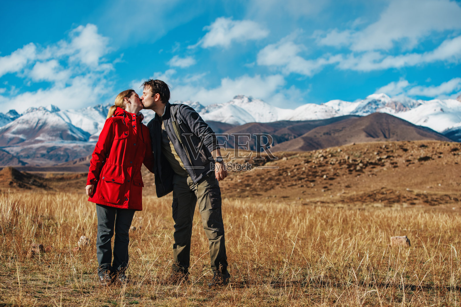 幸福的年轻情侣在秋天的群山背景上接吻照片摄影图片
