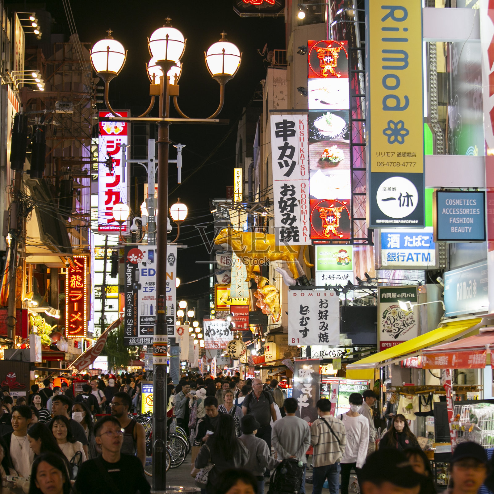 道顿堀街道上的餐馆和游客到处都是街头小吃摊和夜生活。照片摄影图片