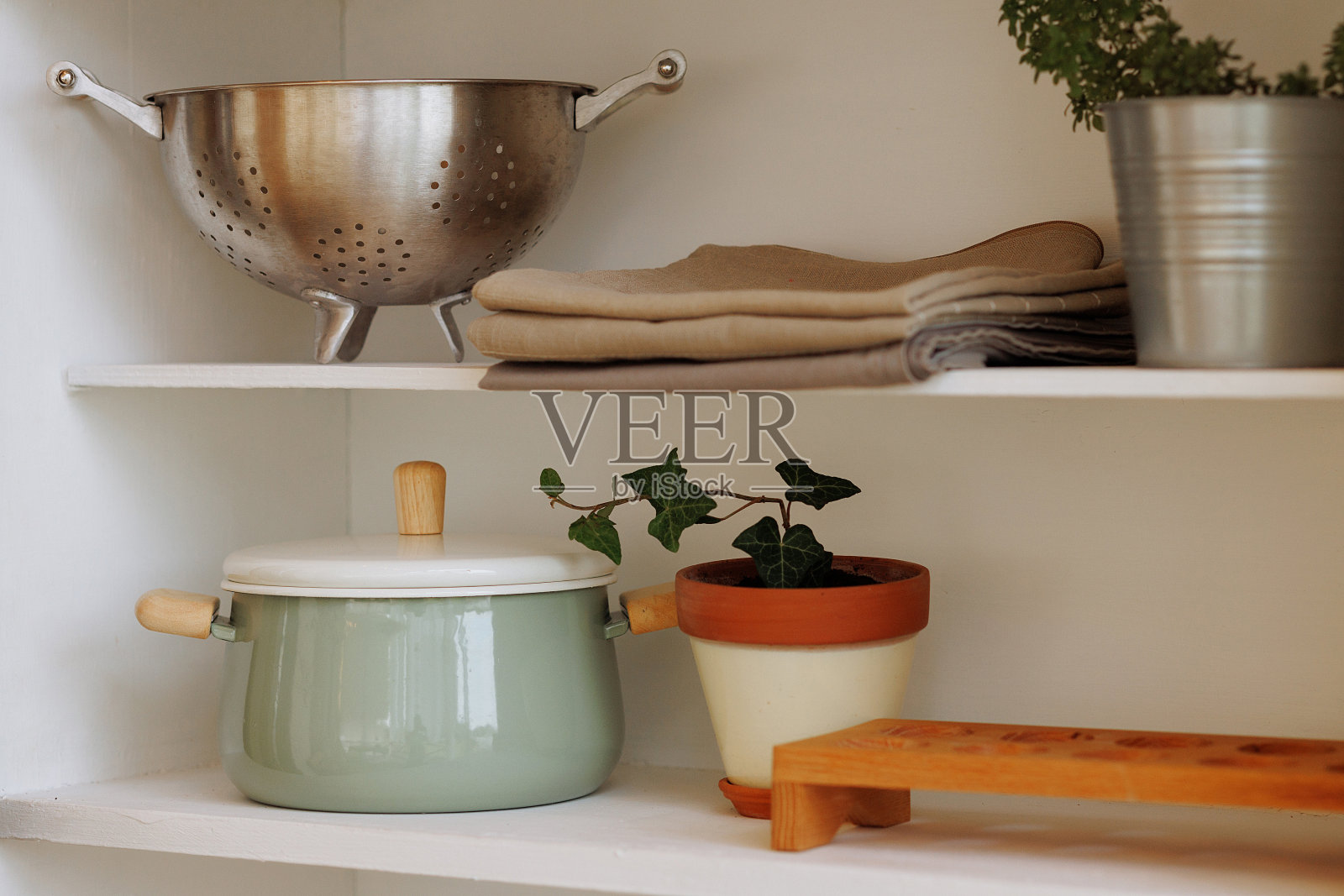 厨房架子上有炊具。照片摄影图片