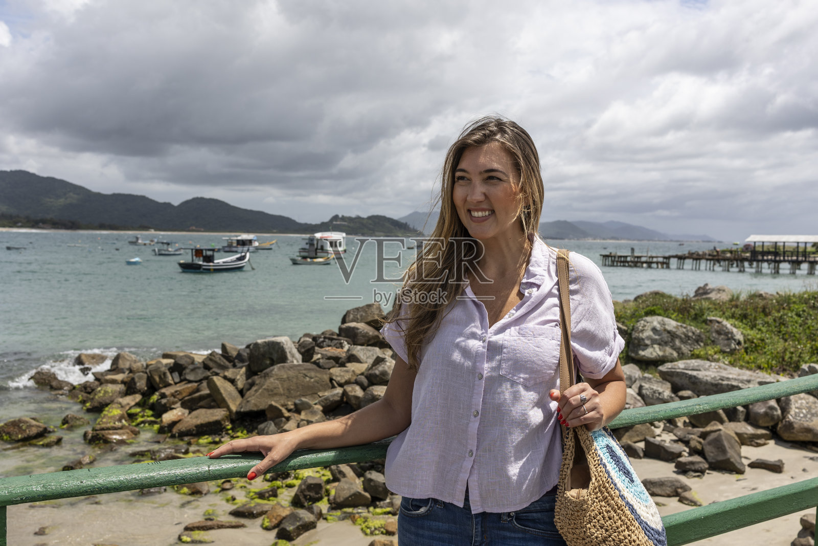 一个快乐的女人站在海边的观景点照片摄影图片