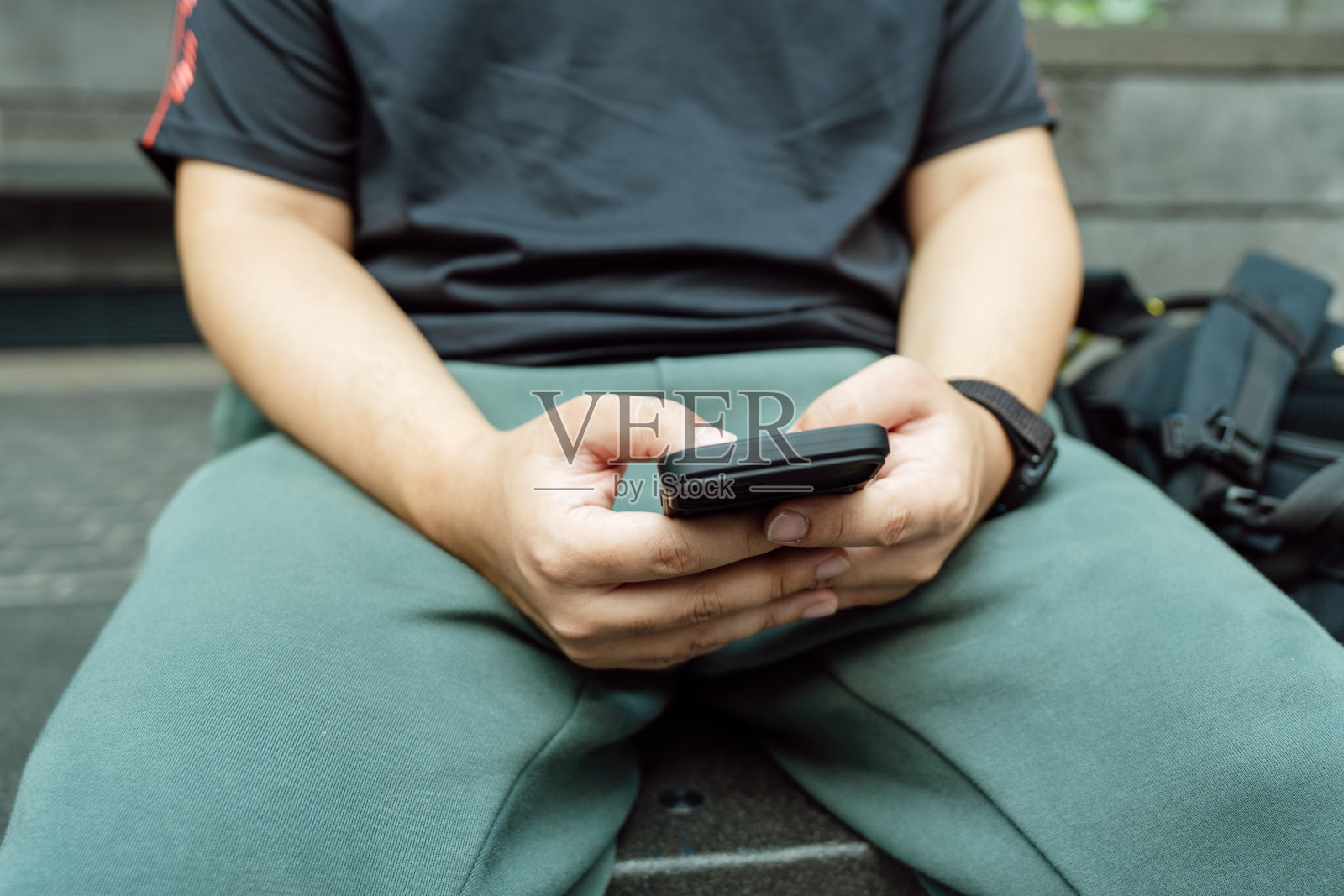 男子在玩手机游戏。玩电子游戏的男孩拿着SmartphoneÂ工作的移动设备。手机技术电子商务概念照片摄影图片