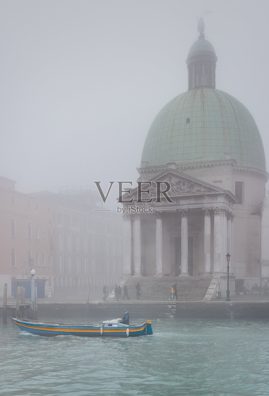 冬天有雾的一天，小船漂浮在威尼斯大运河上，背景是教堂照片摄影图片