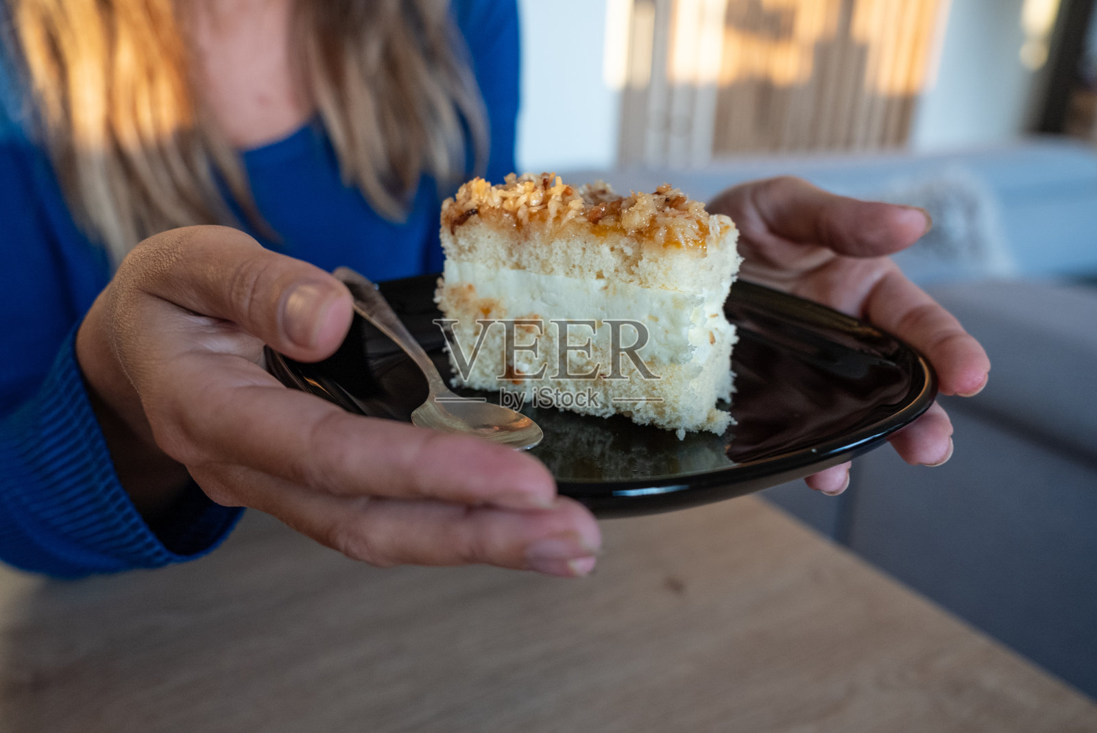 这个女人手里拿着食物。女孩手里拿着。盘子里的蛋糕。照片摄影图片