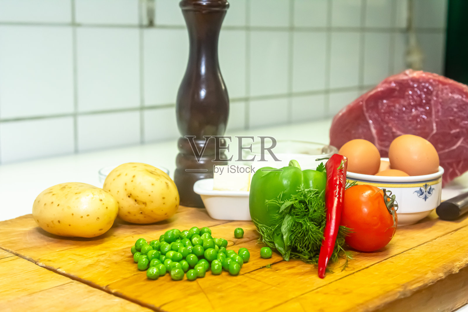 生肉:生的新鲜牛肉猪肉，准备与大蒜，洋葱，欧芹，莳萝，蘑菇，鹌鹑蛋，调味料，盐，香菜和红辣椒一起在木桌上烹饪。加调料的生肉。照片摄影图片