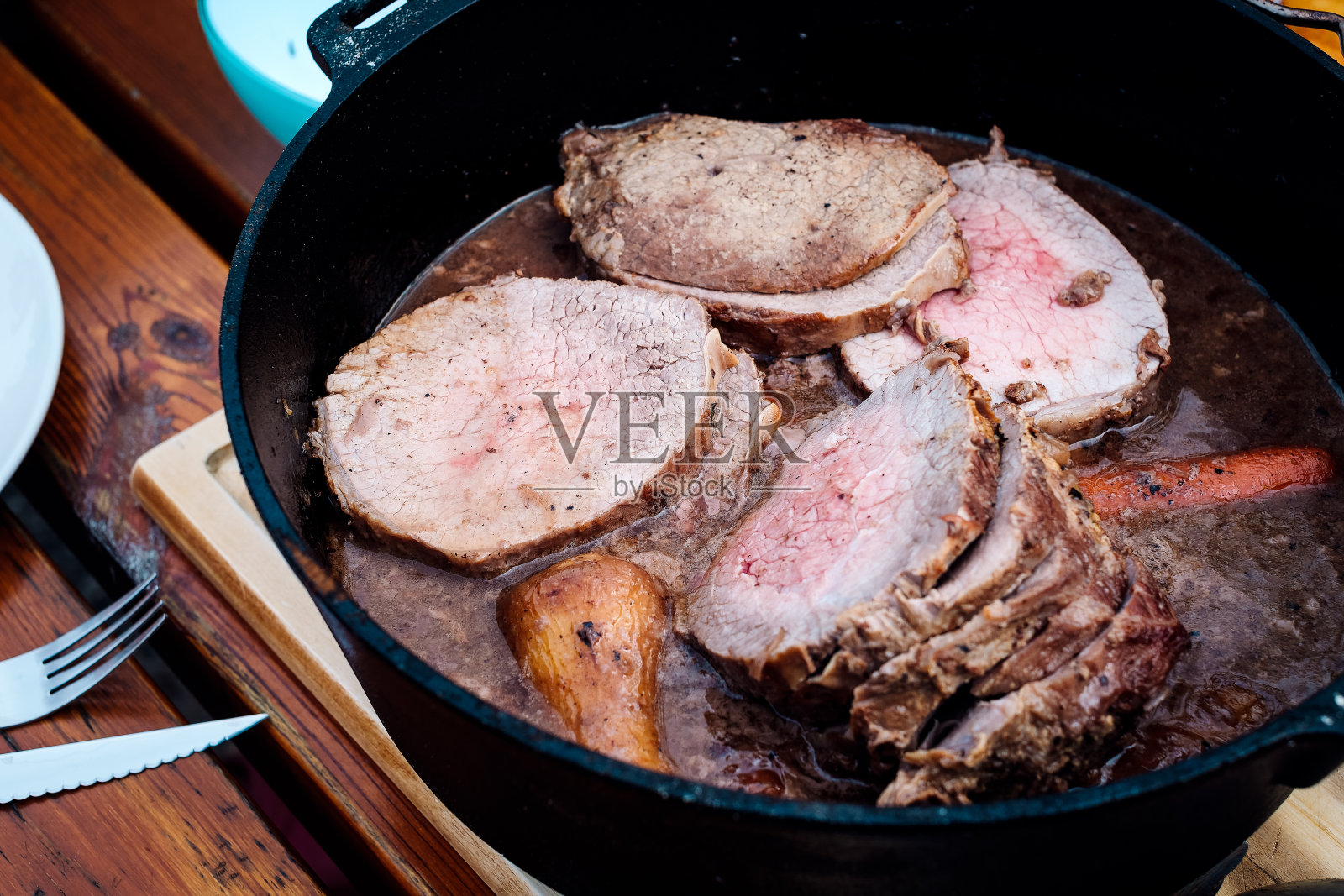 荷兰烤箱烤牛肉，胡萝卜和洋葱照片摄影图片