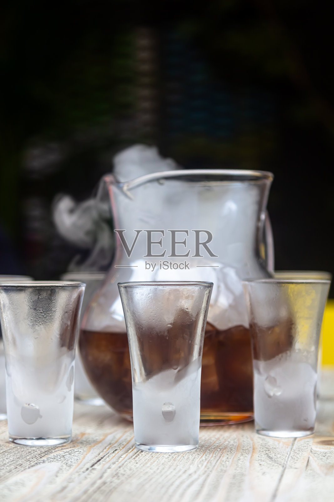 威士忌酒烟。在黑暗的背景下吸着加了冰和橙汁的威士忌。干邑白兰地带有烟熏薰衣草。照片摄影图片