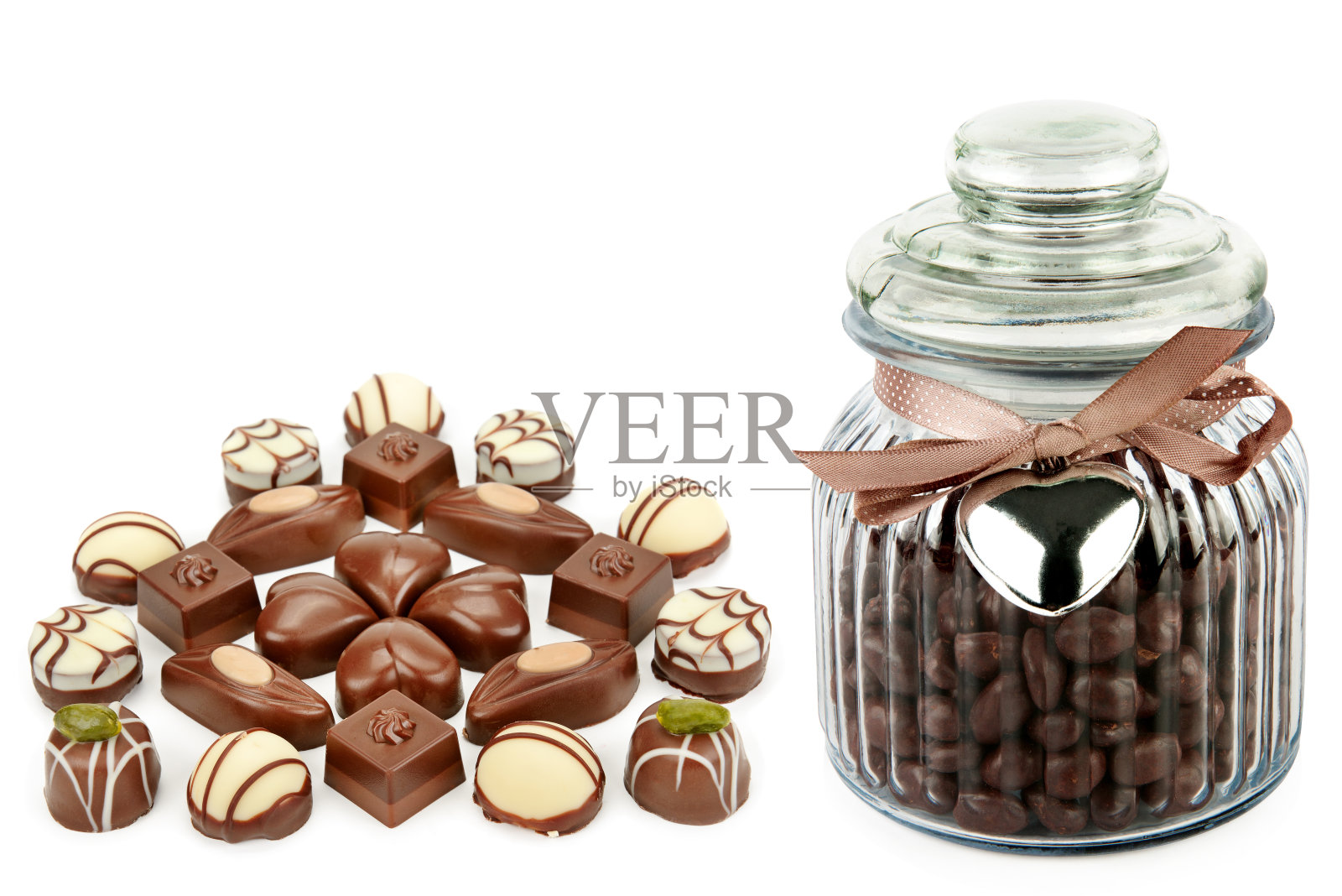 一套巧克力糖果和巧克力糖浆在一个玻璃罐隔离在白色。文本的自由空间。拼贴画。照片摄影图片