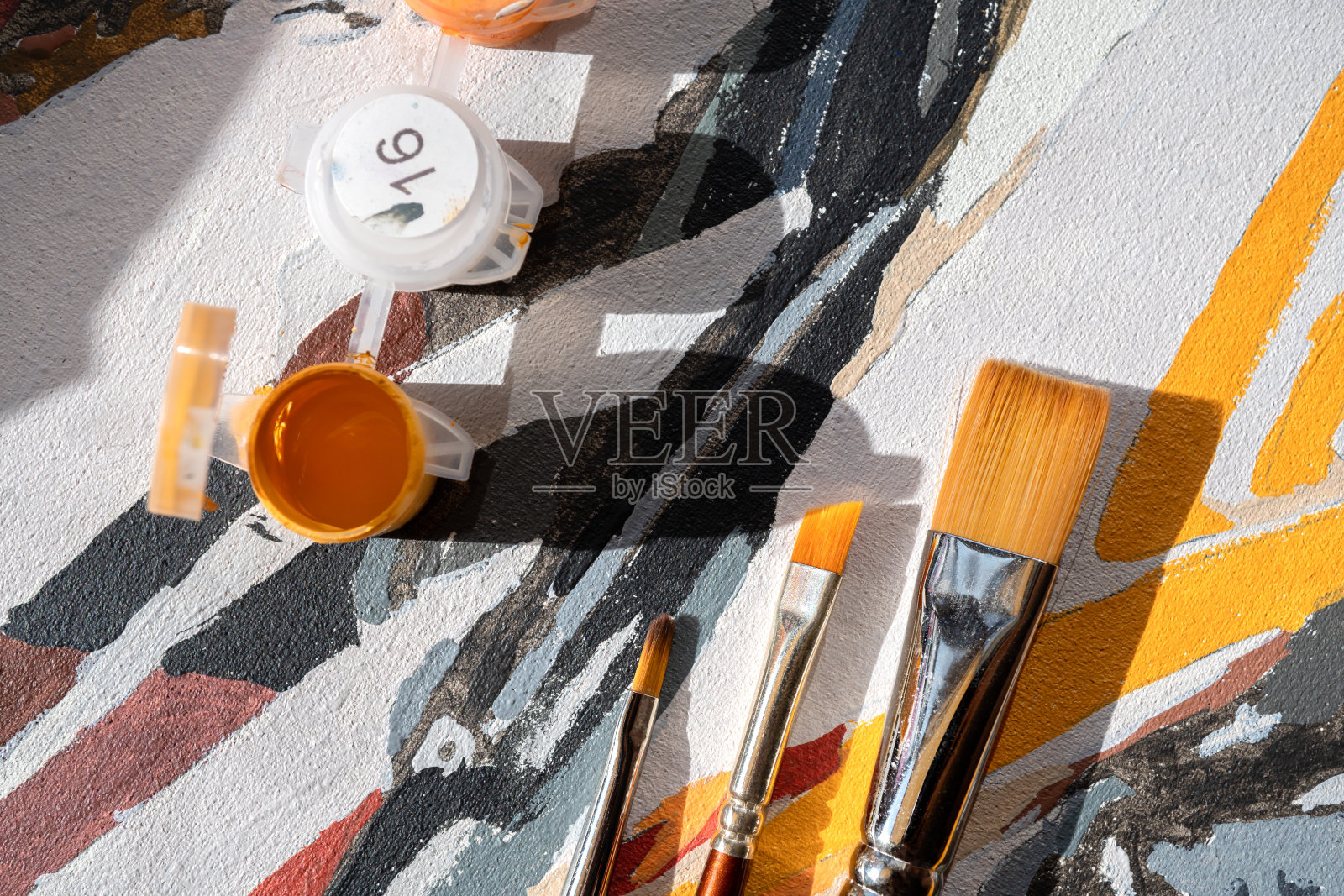 丙烯颜料和画笔在画布上。照片摄影图片