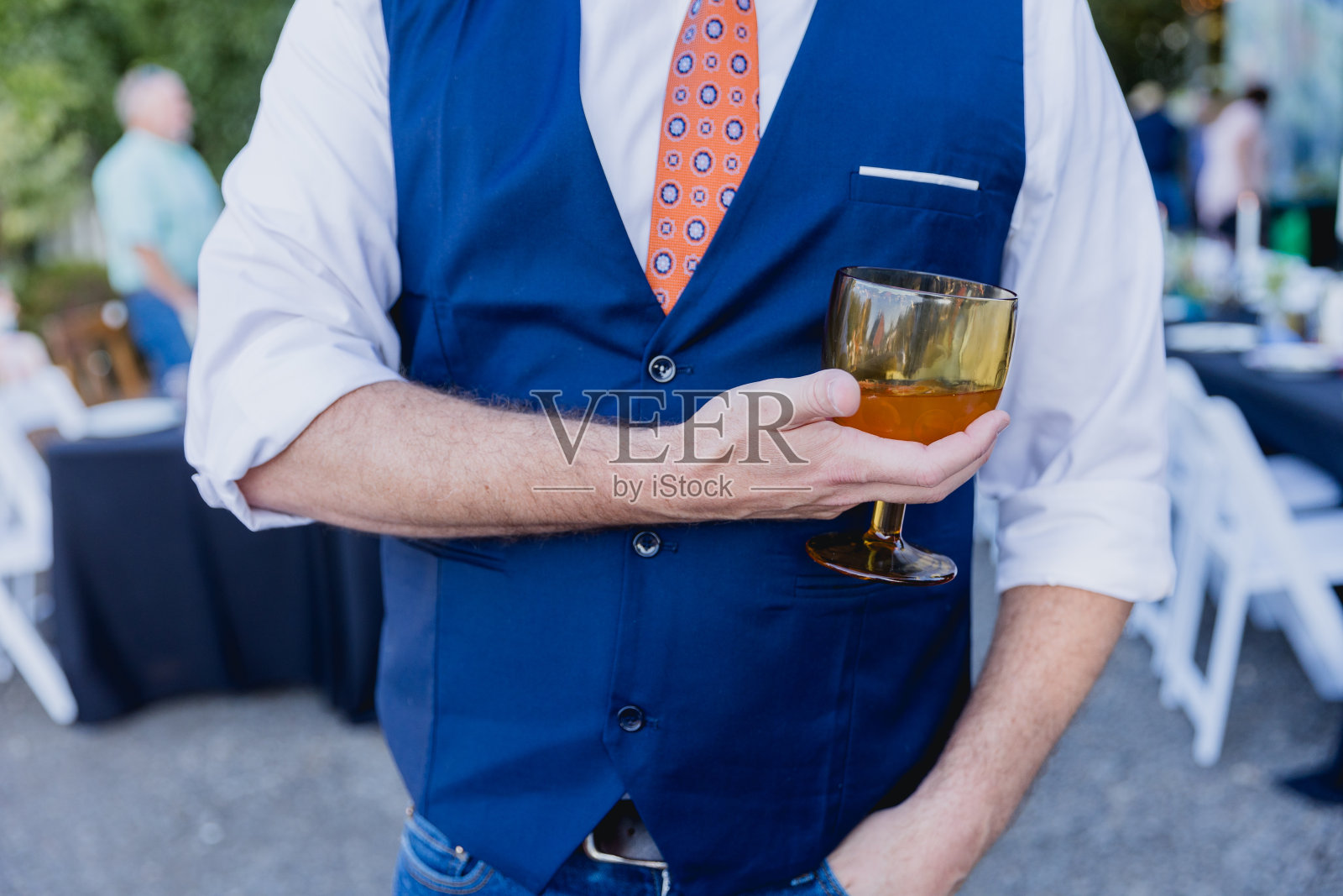 在正式的社交活动中拿着杯子和饮料的人照片摄影图片