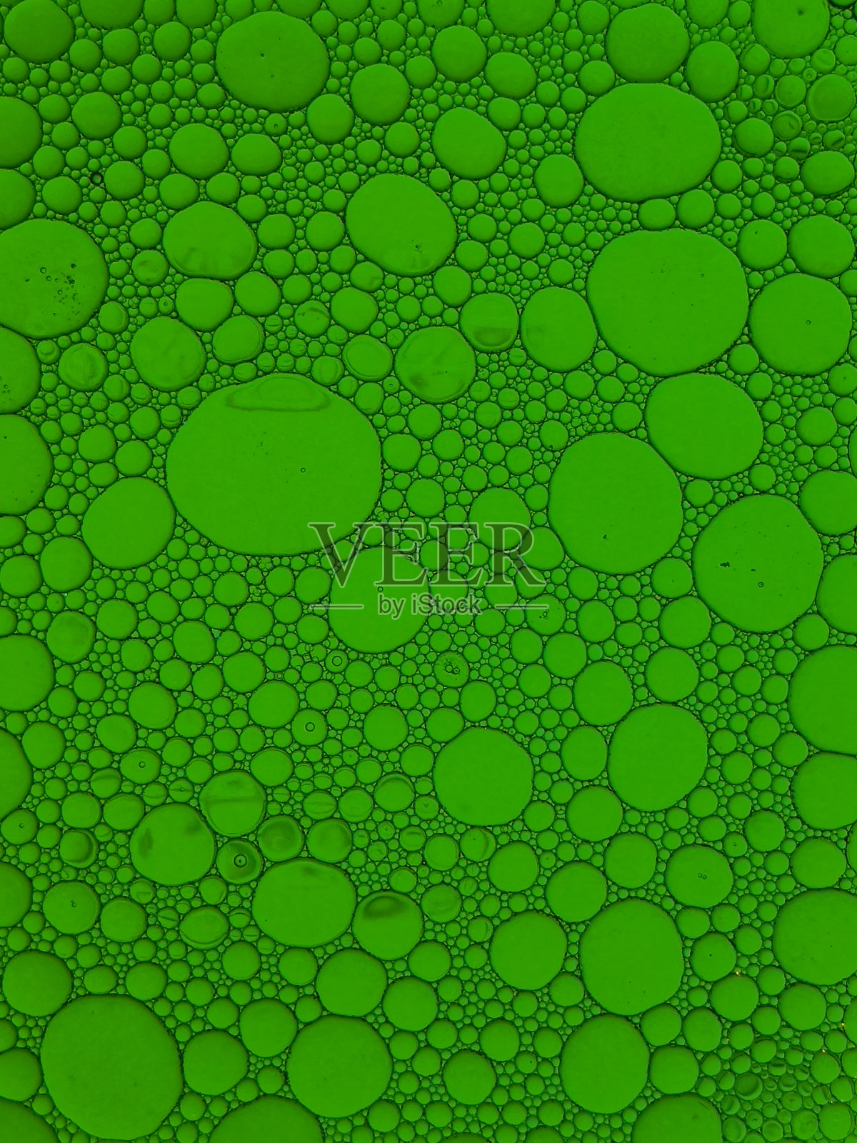 用食用油和水混合而成的绿色背景。照片摄影图片