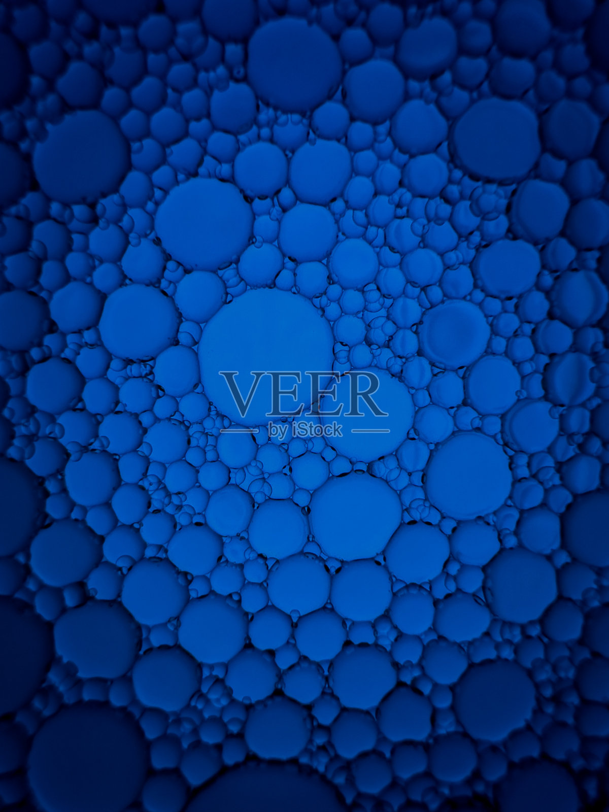 用食用油和水混合而成的蓝色背景。照片摄影图片