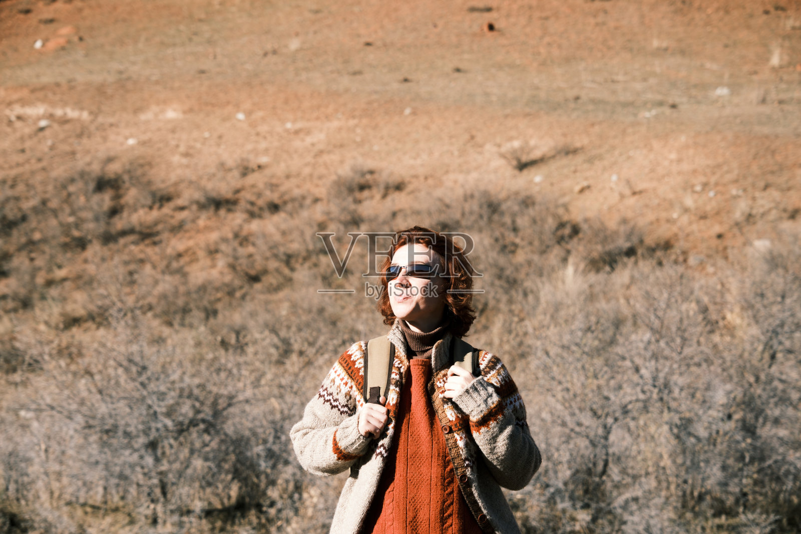 冬日里，一位45岁的开朗女子正在山间河岸上徒步旅行照片摄影图片