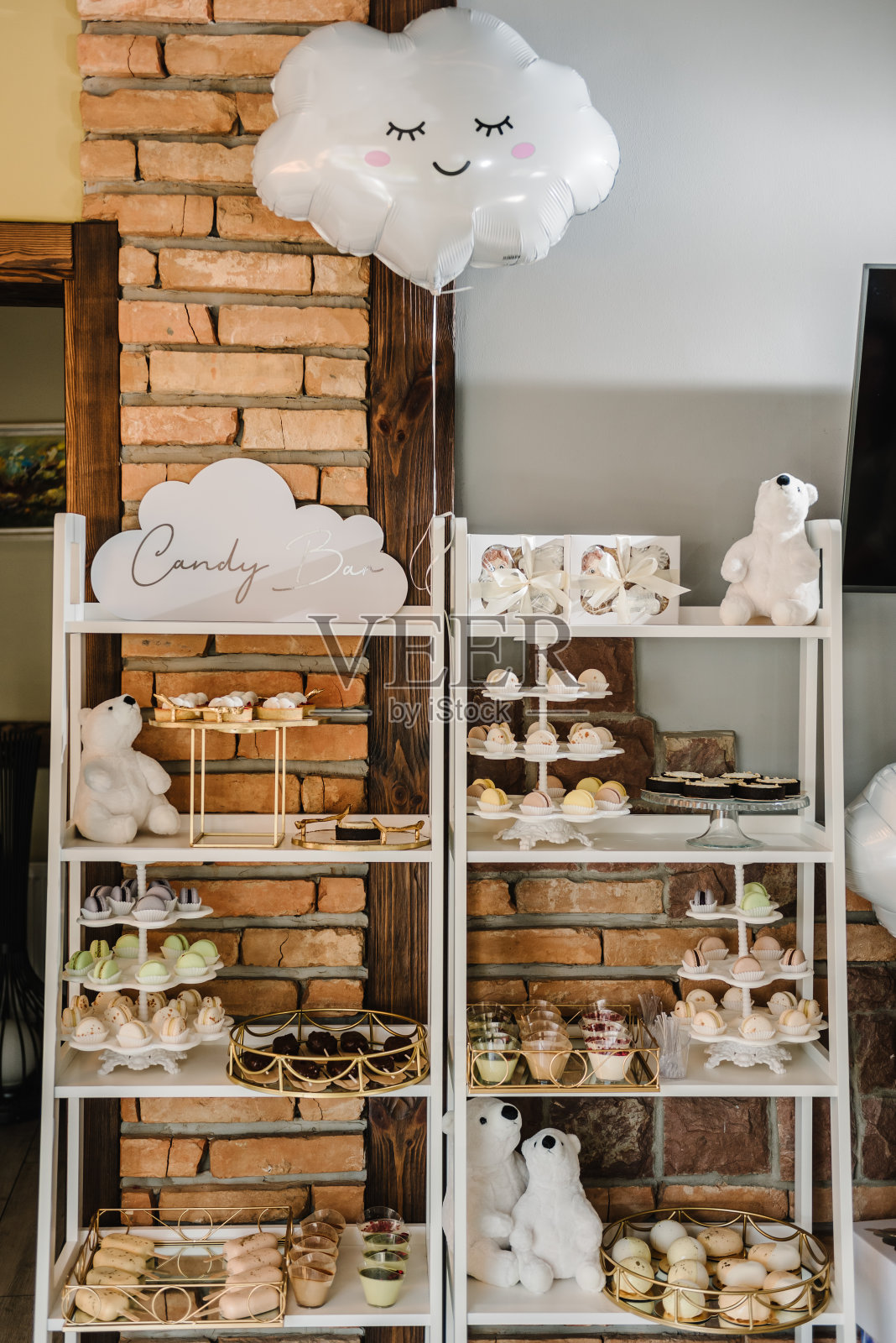 孩子生日派对或洗礼时的糖果棒。美味的接待奢华的仪式。桌上摆满了糖果、糖果、甜点、冰淇淋和杏仁饼。桌子上放着毛绒玩具熊和气球。照片摄影图片