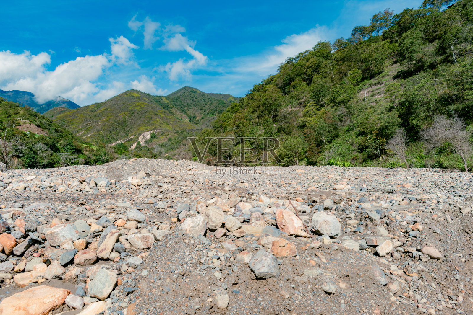 多山的景观与河流的石头造成的雪崩和强烈的夏天照片摄影图片