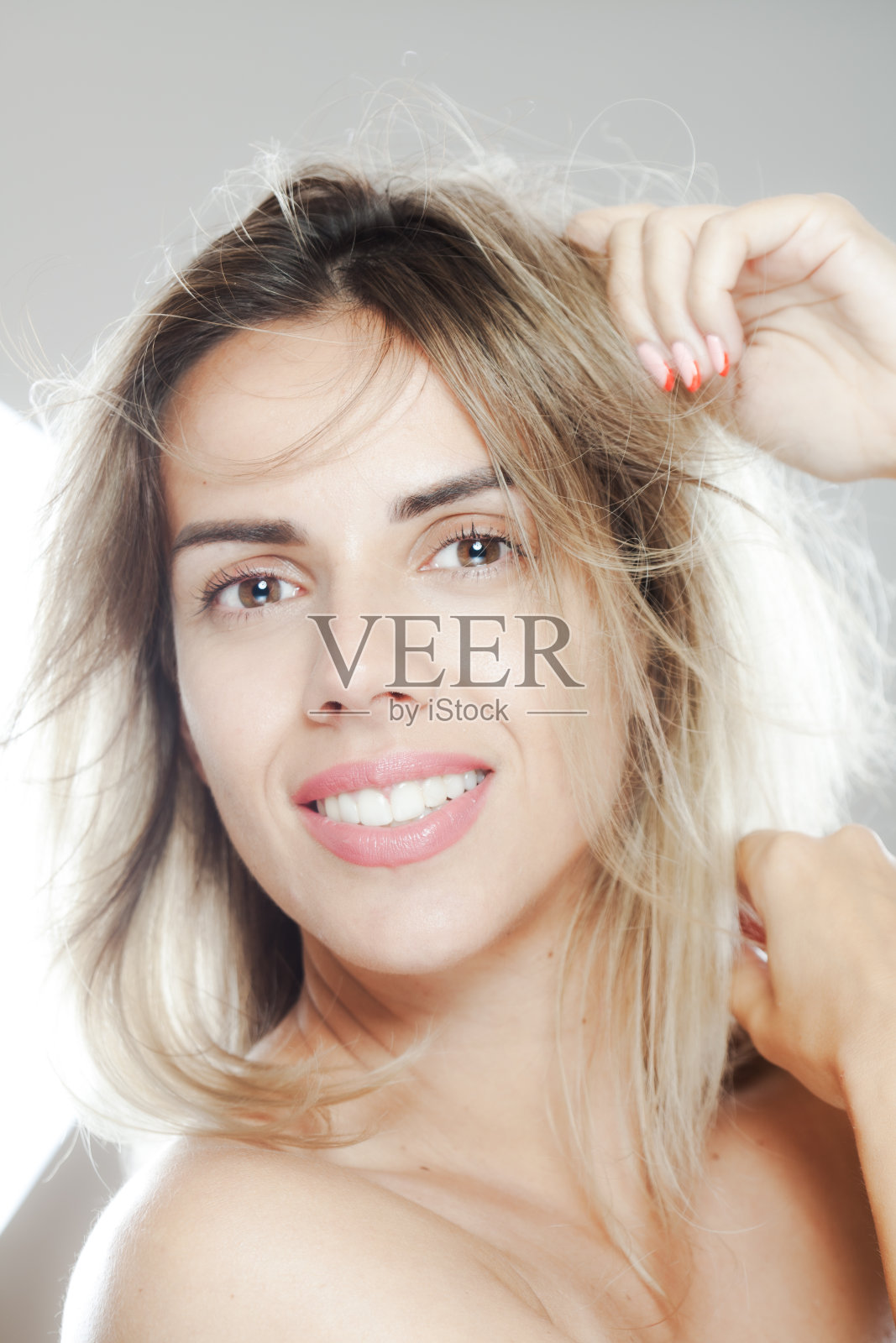 一个美丽的女人微笑的肖像，随意的工作室拍摄与自然光照片摄影图片