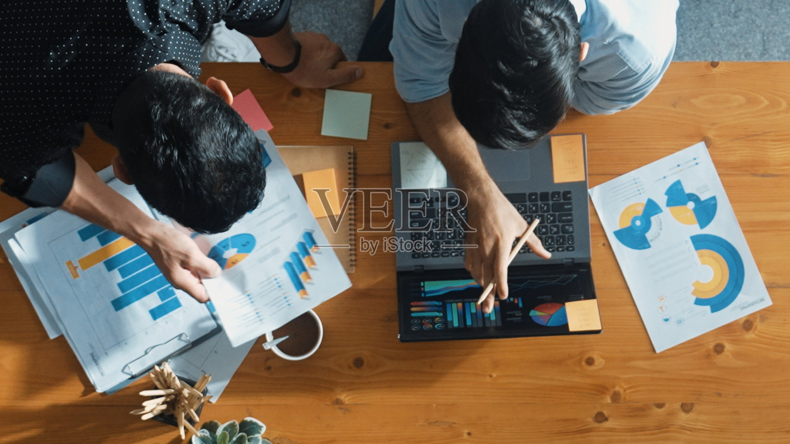 项目经理走在桌子旁，同事们在头脑风暴。召开。照片摄影图片