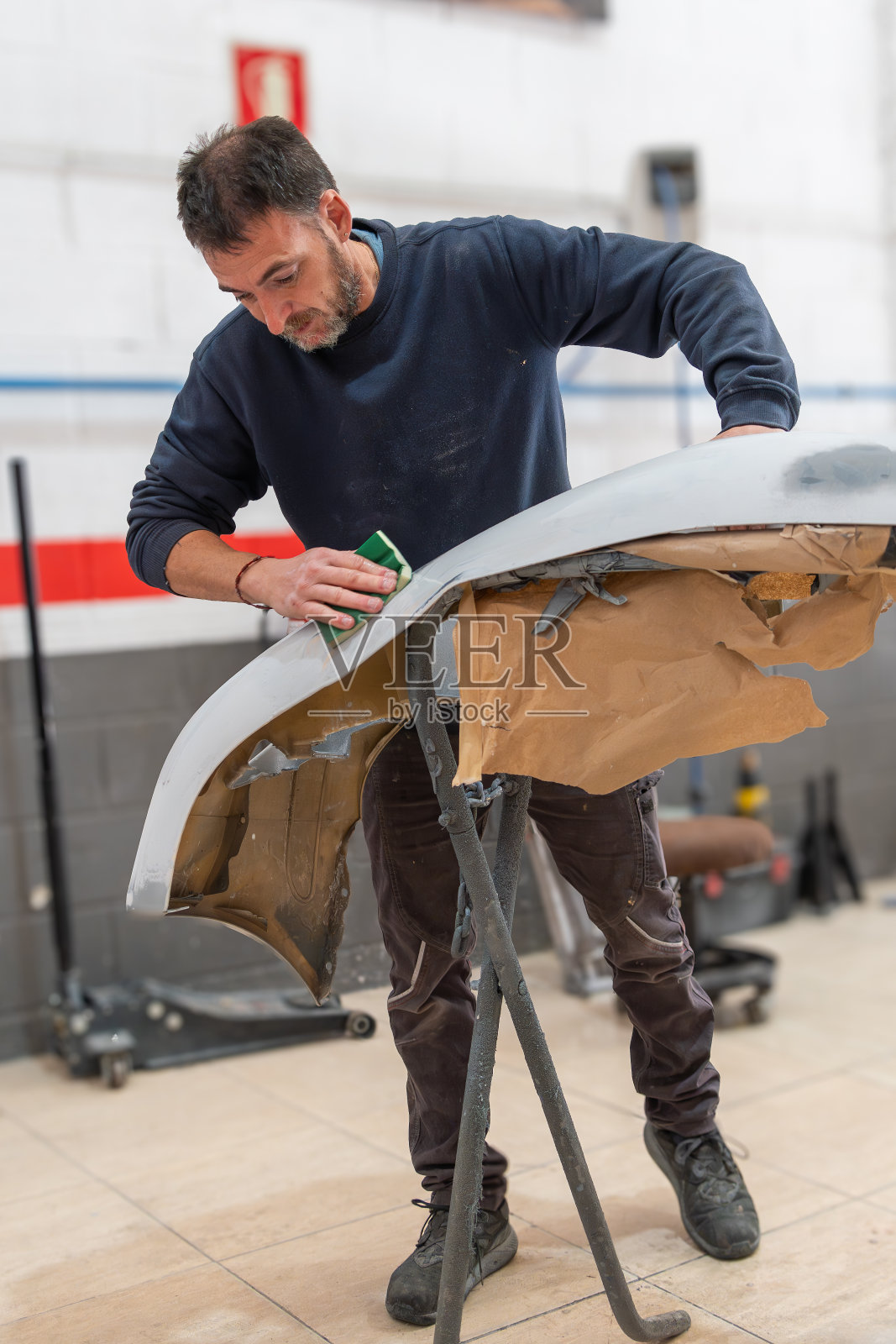 专职机械师为汽车保险杠喷漆做准备照片摄影图片