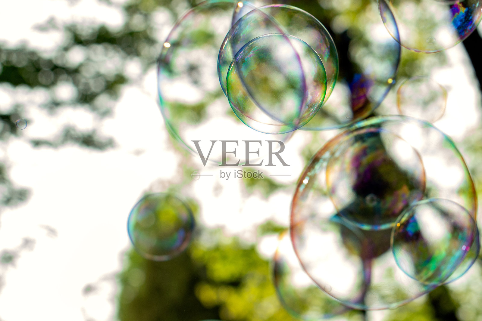 以阳光和绿色为背景的肥皂泡特写，抽象的背景，积极的情绪，假期，粗心大意照片摄影图片