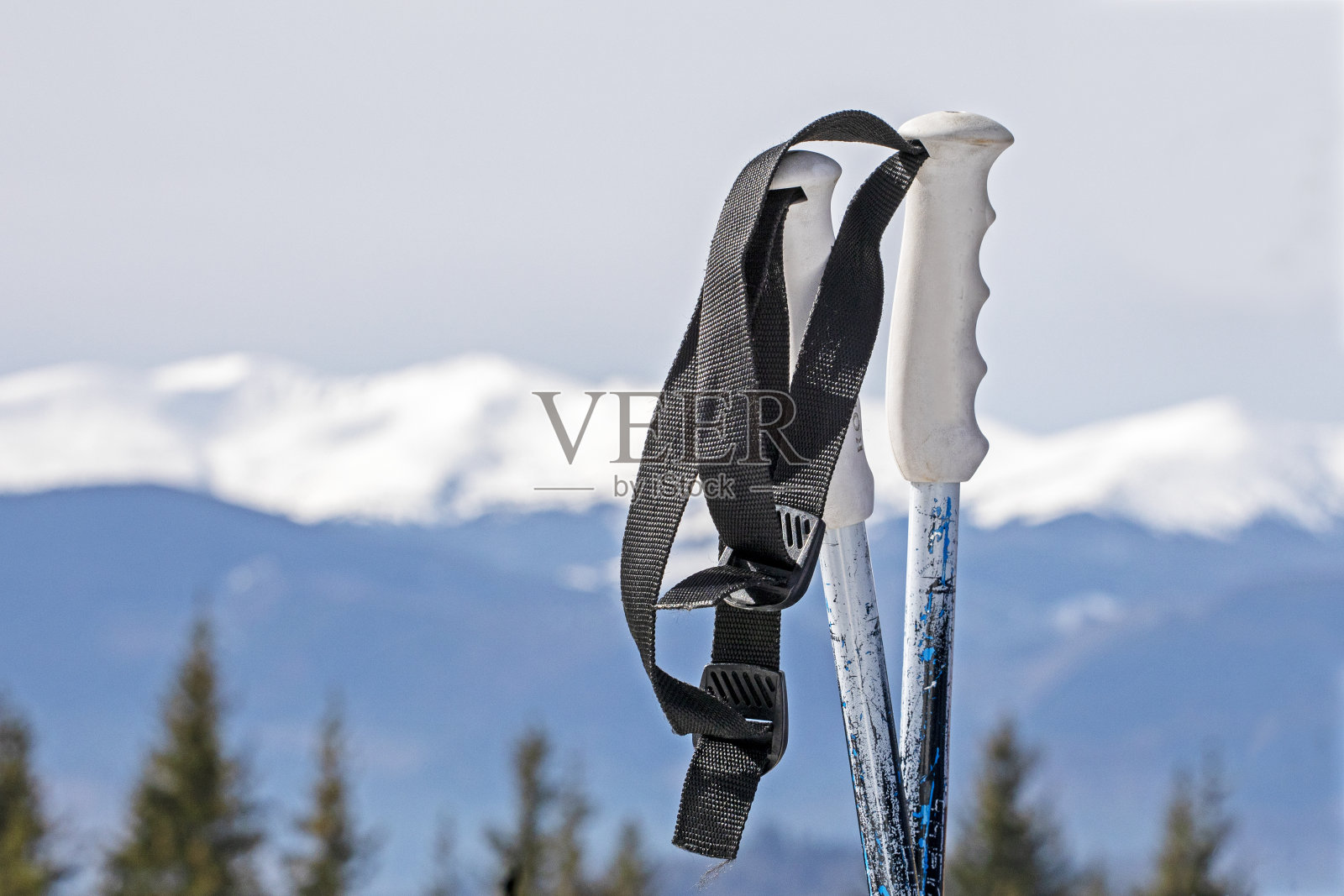 滑雪胜地的雪峰背景下的滑雪杖。活动及学校假期照片摄影图片