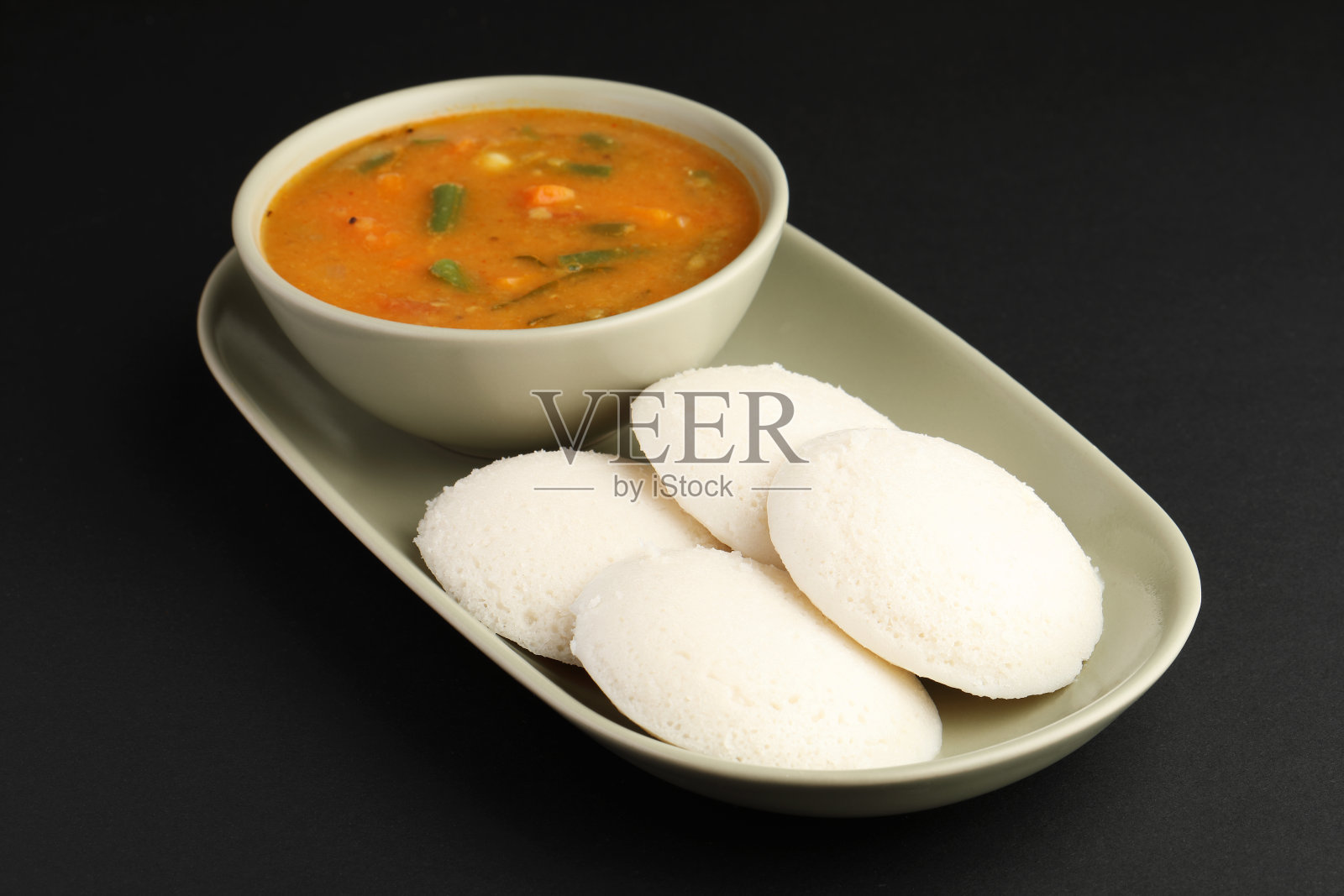 懒散的桑巴或伊德里，桑巴和绿色，红色的酸辣酱。流行的南印度早餐照片摄影图片