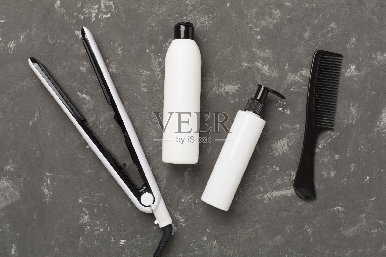 在混凝土背景，顶部，视图上带有热保护的直发器照片摄影图片