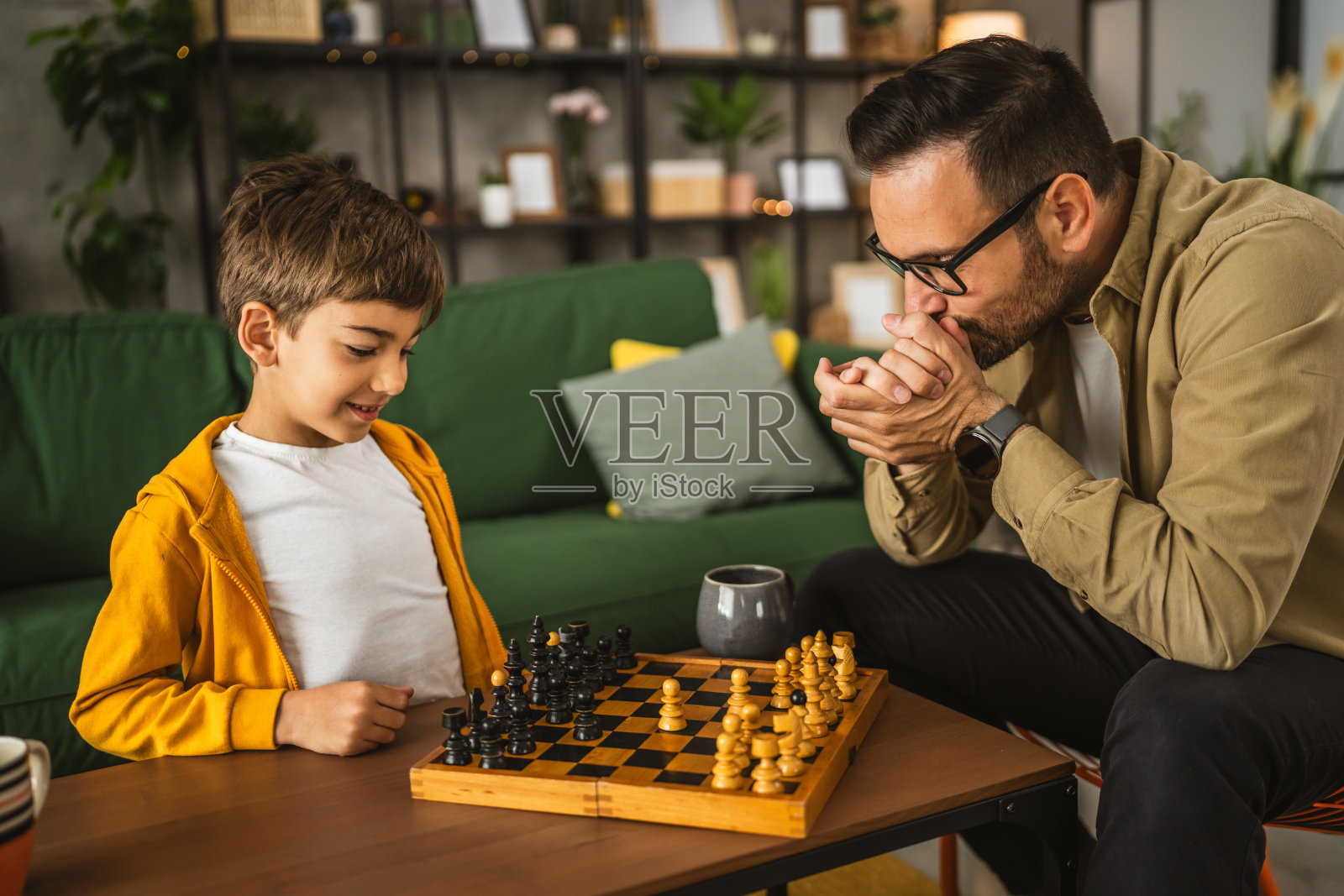 父子俩在家里一起下棋照片摄影图片