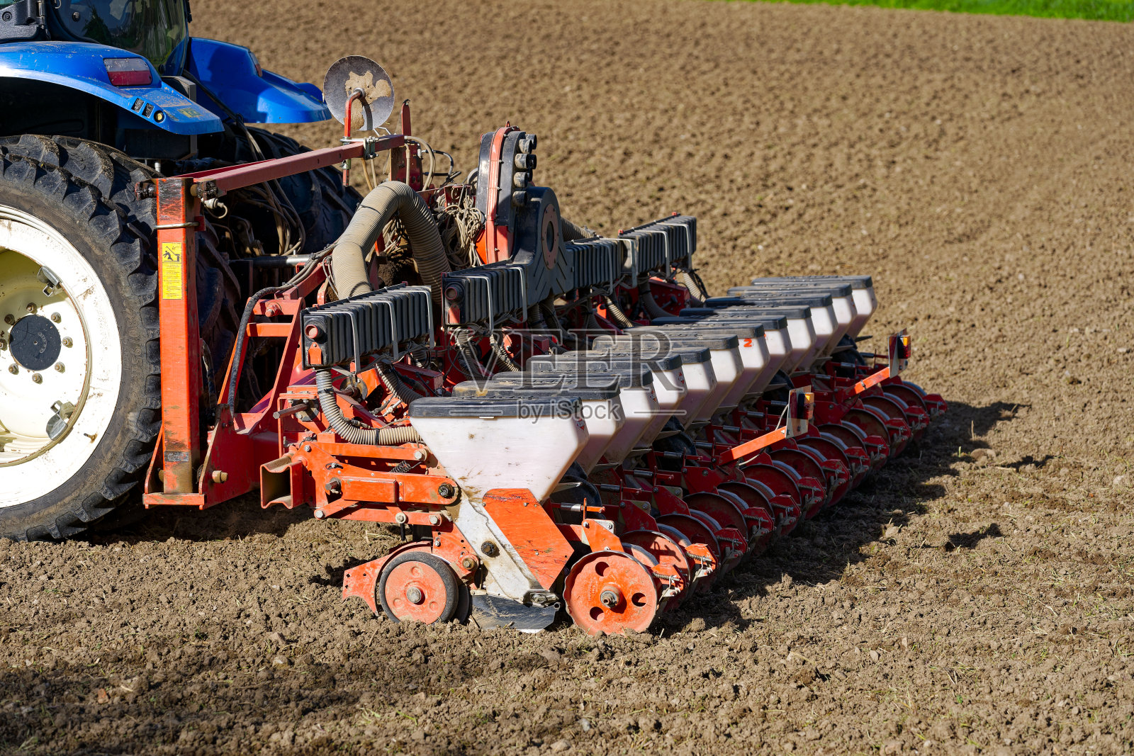 在明媚的阳光下，瑞士小镇的农田里自动播种向日葵种子。照片摄影图片