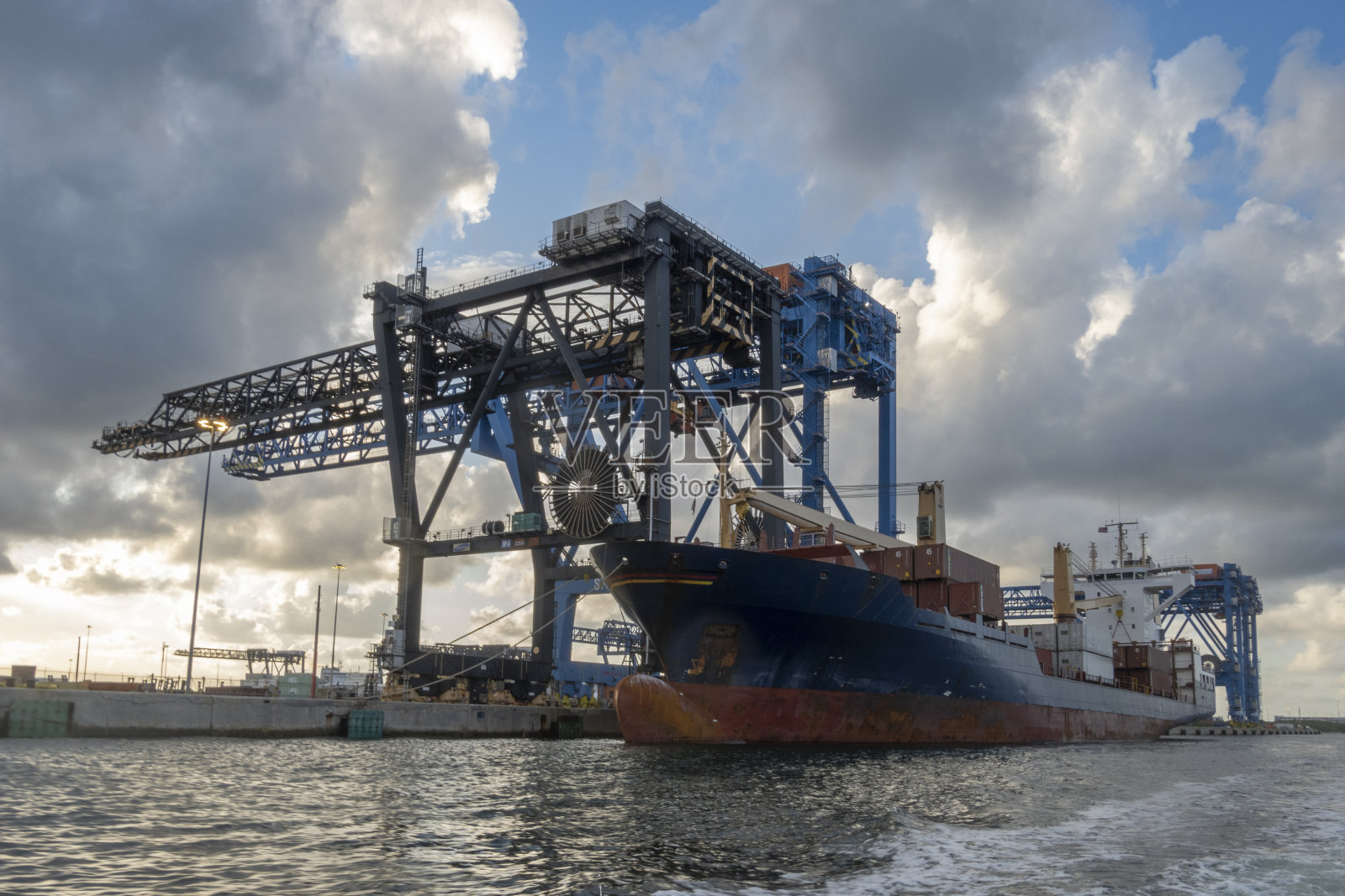 日落时分有起重机的海港照片摄影图片