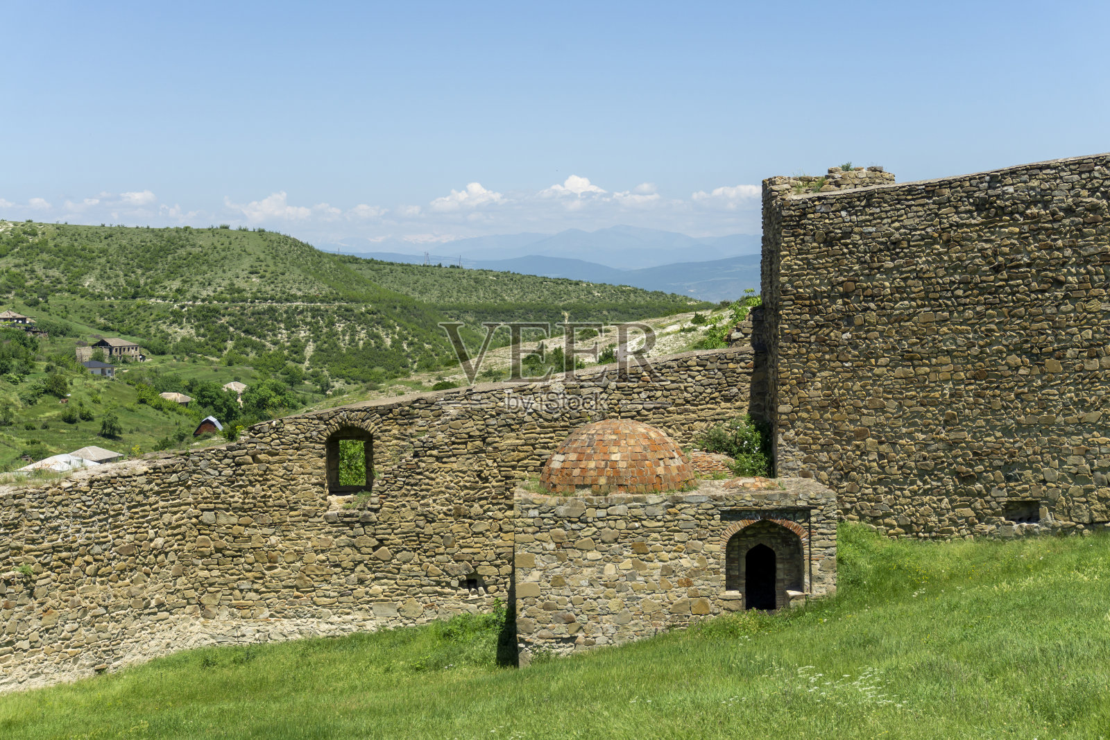 城堡院子里的中世纪澡堂。石墙，橙砖圆顶，拱门入口照片摄影图片