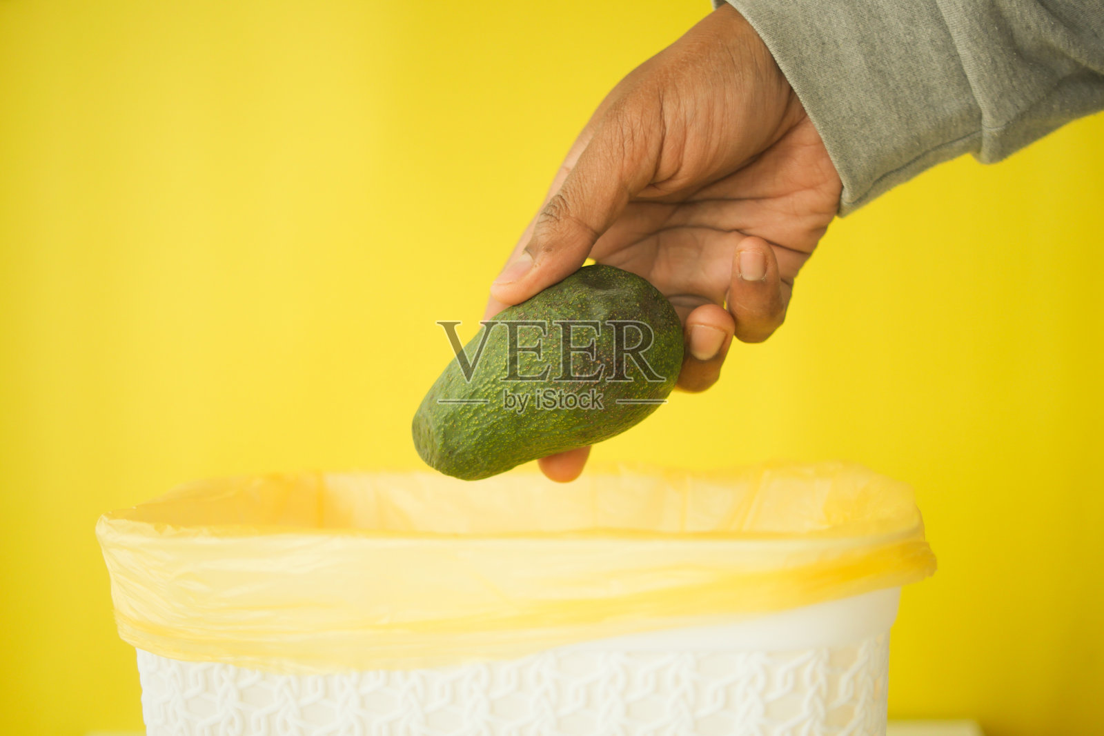 把牛油果扔进垃圾桶照片摄影图片