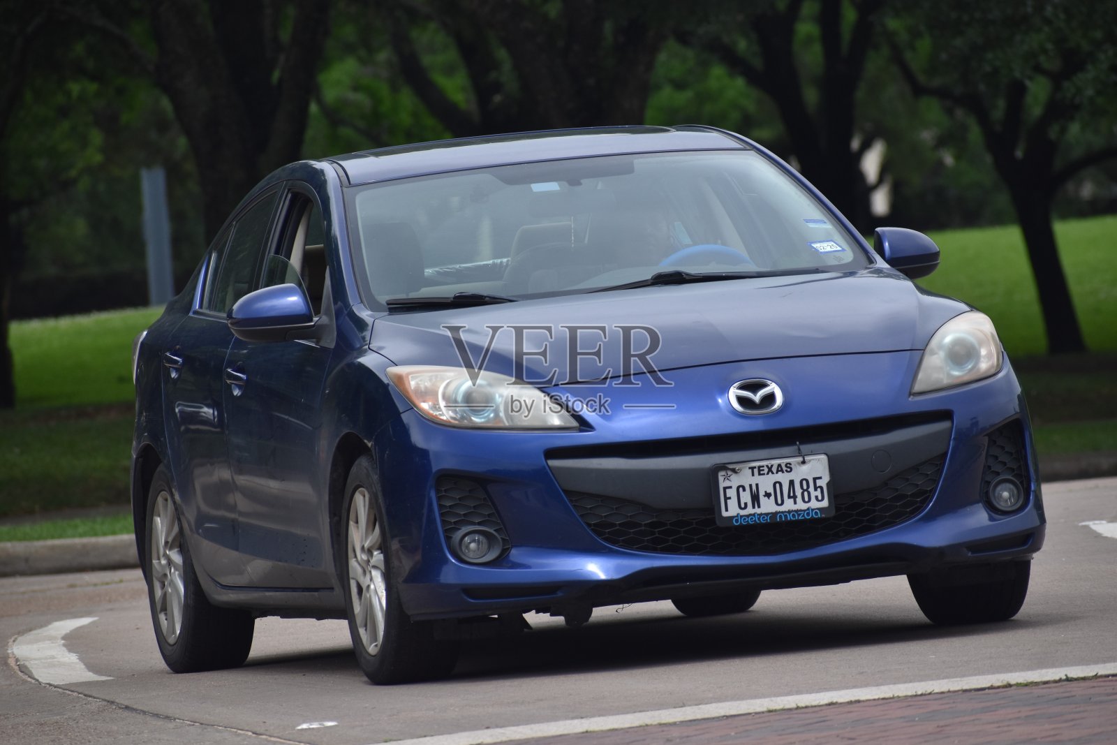 一辆蓝色的马自达3轿车在休斯敦赫尔曼公园巡游照片摄影图片