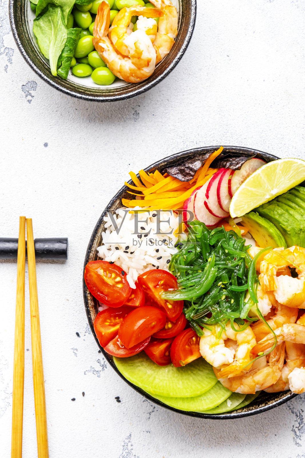 dy平衡。有虾，米饭，鳄梨，蔬菜和chuka沙拉的Poke碗，白色的桌子背景，俯视图照片摄影图片