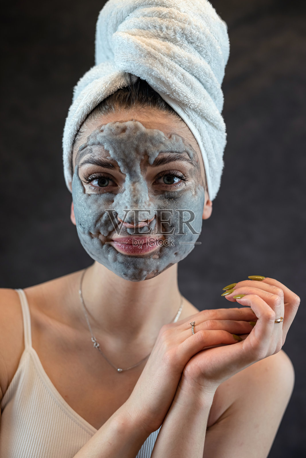 女性面部用灰色泡泡面膜作为抗衰老治疗，完美隔离肌肤上的黑色照片摄影图片