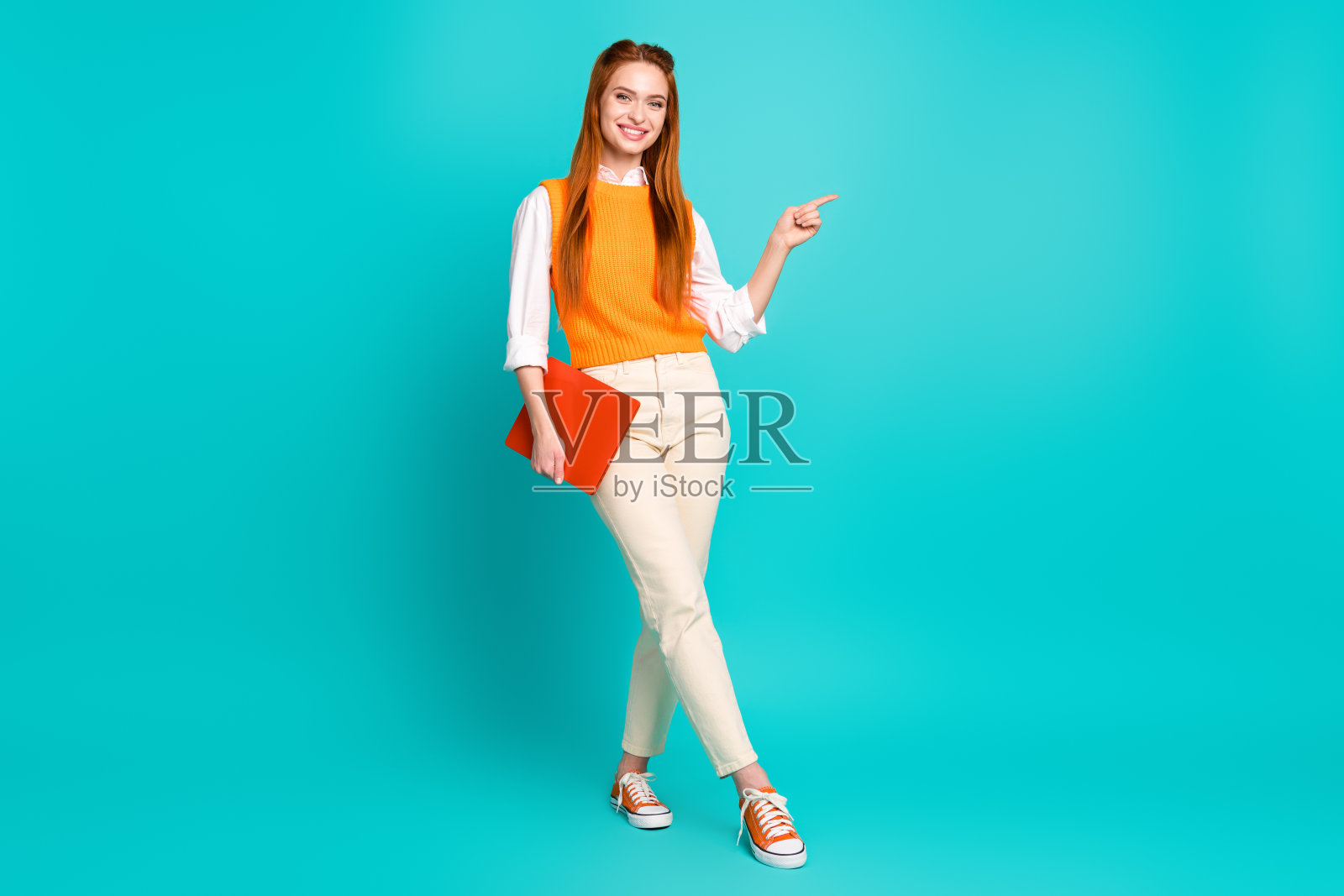 可爱可爱的女人穿着时尚的衣服的全身照片推荐小工具空的空间孤立在青色的背景照片摄影图片