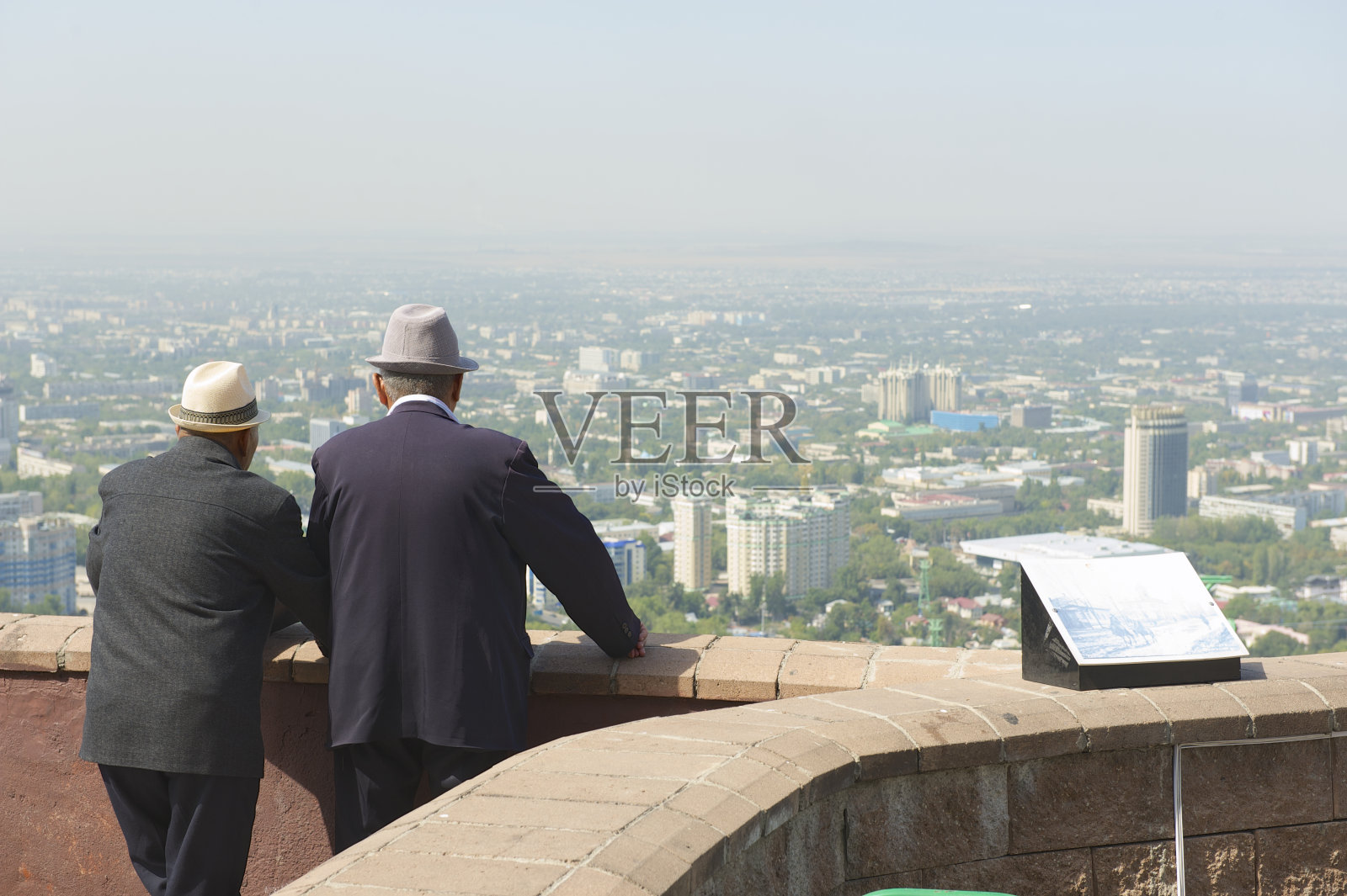 两位老人欣赏着哈萨克斯坦阿拉木图市的景色。照片摄影图片