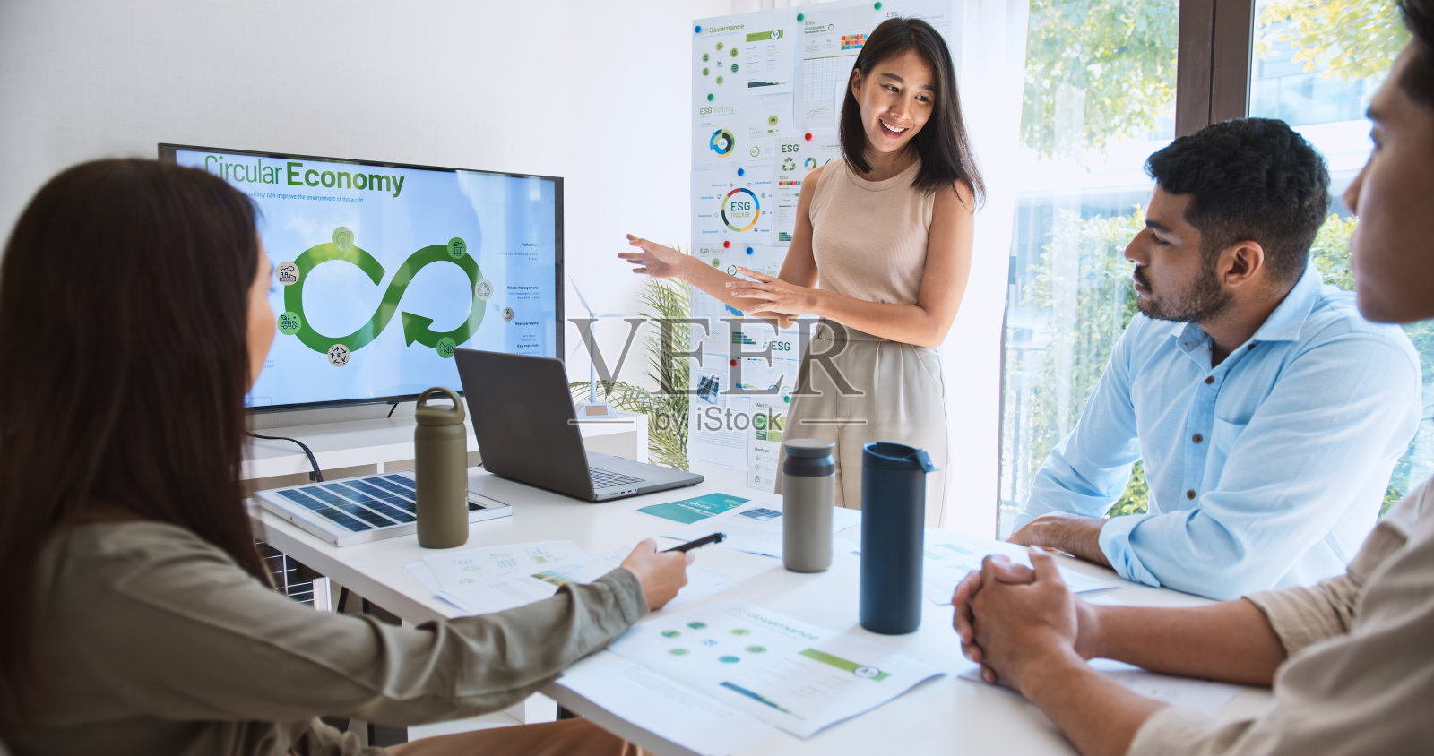 亚洲女性在团队会议上带领一群年轻的多民族商人，使用笔记本电脑在监视器上进行ESG主题演讲。可持续的商业实践，人们在家工作的理念照片摄影图片