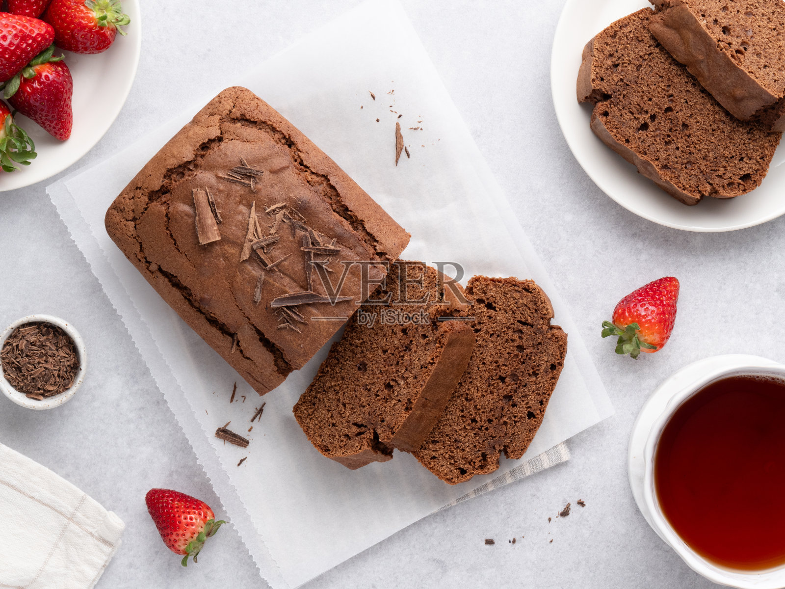 巧克力磅蛋糕。茶饼切成片，配上红茶杯。顶视图表。照片摄影图片