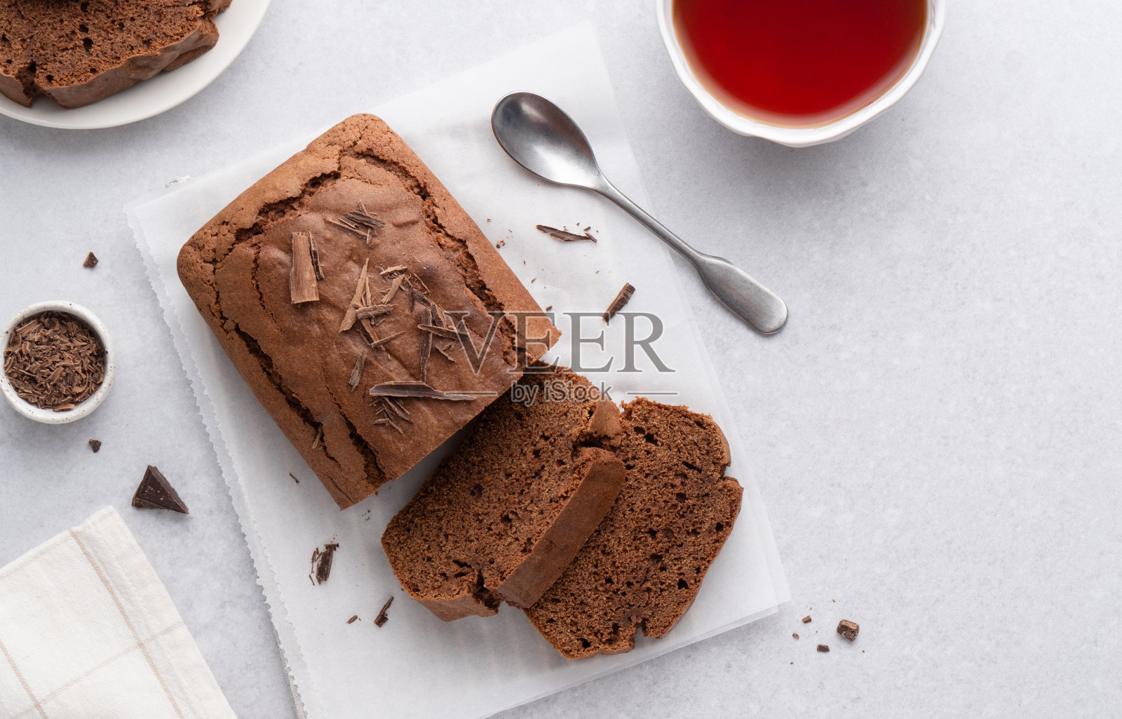 巧克力磅蛋糕。茶饼切成片，配上红茶杯。顶视图表。照片摄影图片