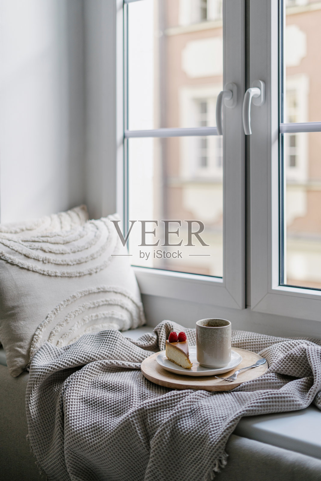 窗台上舒适的地方，有软格纹软垫，一杯咖啡和蛋糕照片摄影图片