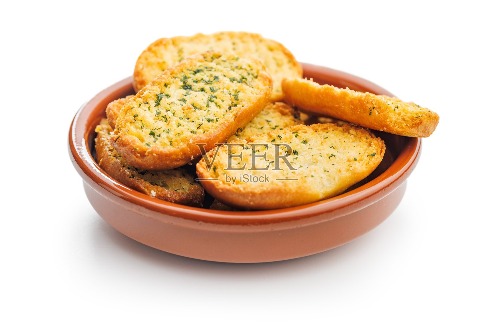 大蒜脆面包片配以香草，在碗中孤立的白色背景。照片摄影图片