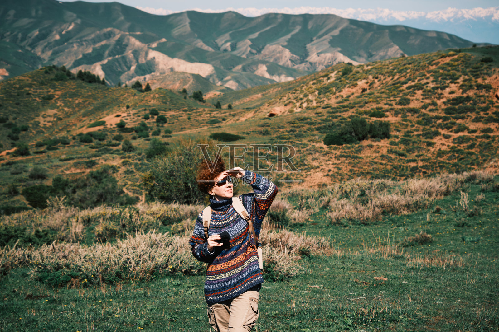 快乐的女徒步旅行者正在拍摄春天的山脉照片摄影图片
