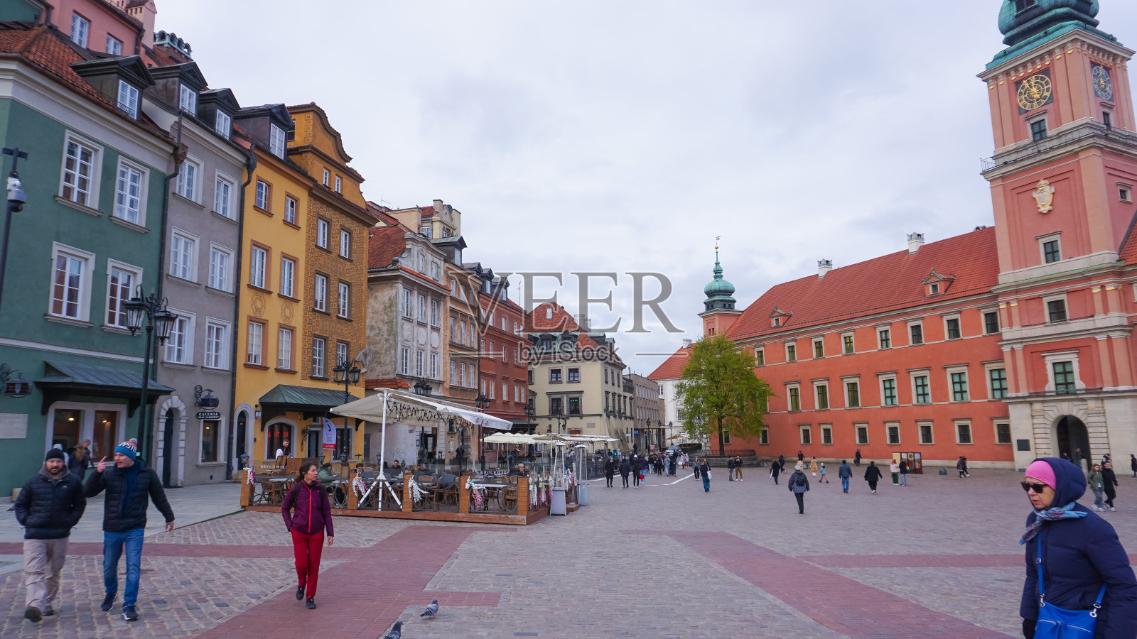 波兰,华沙,人们在老城市场广场上走过色彩斑斓的老房子照片摄影图片