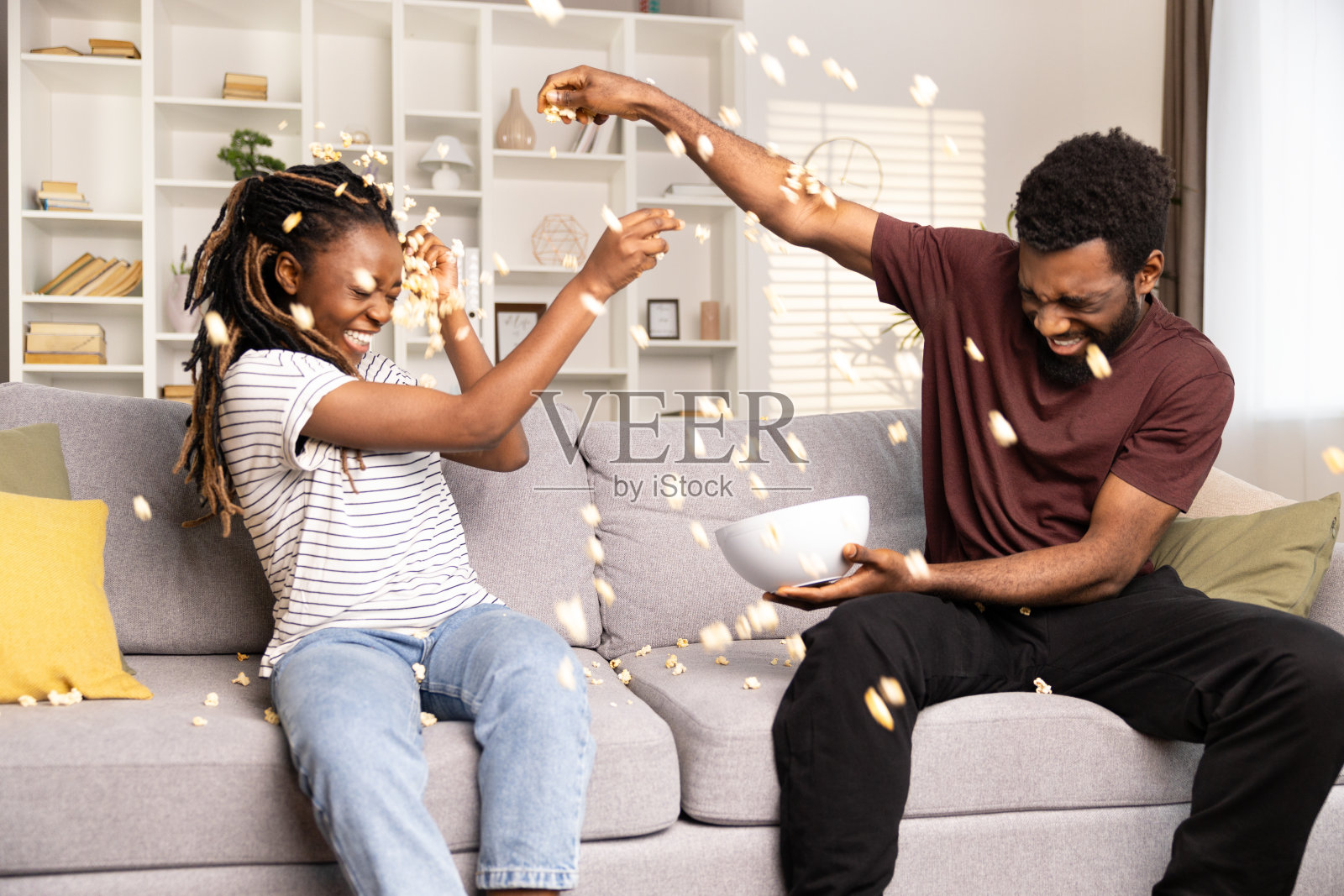 快乐的夫妇在家里玩爆米花照片摄影图片