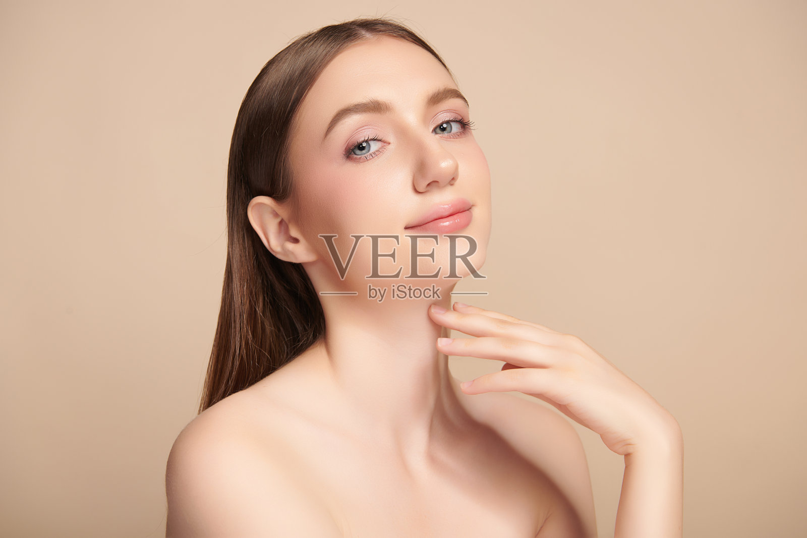 美丽的年轻女子干净新鲜的皮肤在米色背景，面部护理，面部治疗，美容，美容和水疗，女性肖像。照片摄影图片