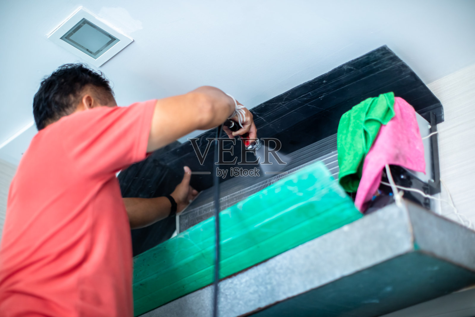 技师手中的高压水喷头选择性地清洗空调冷却盘管面板。照片摄影图片