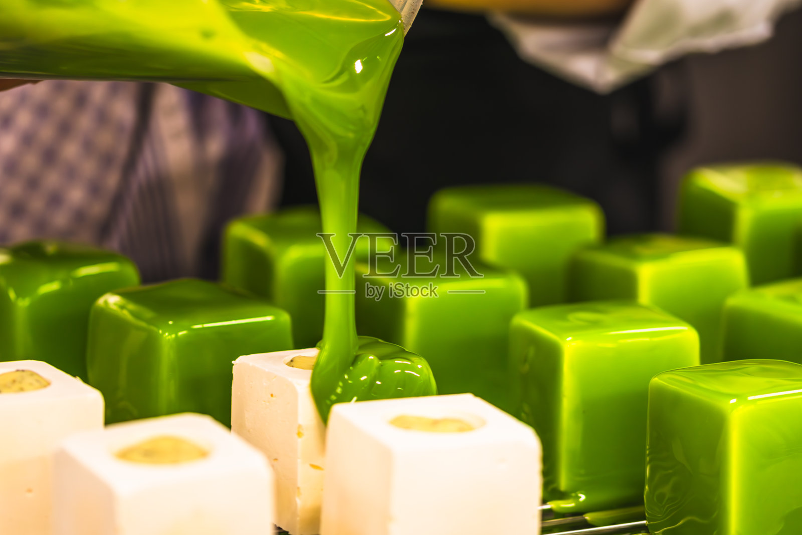 糖果师正在给馅饼上绿釉。由专业的糕点师制作馅饼。照片摄影图片