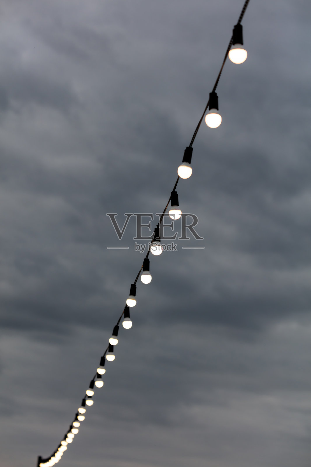 节日的灯泡在天空白云的背景下闪闪发光照片摄影图片