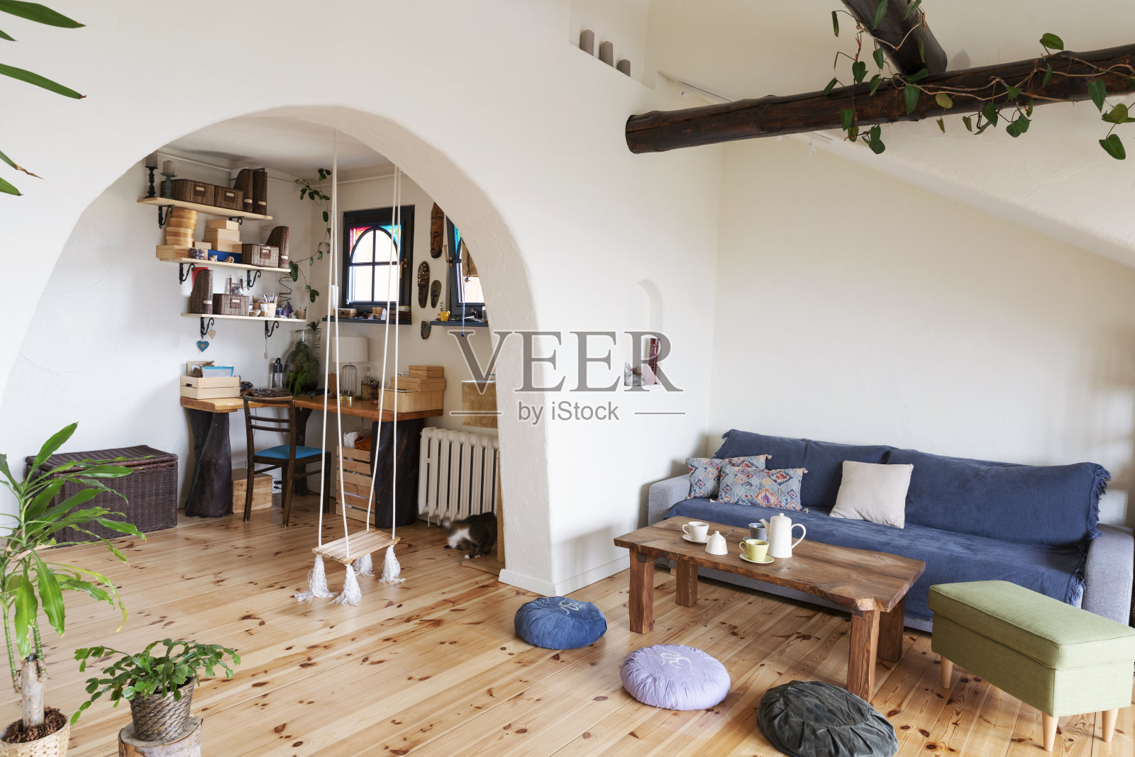 白色拱墙、沙发和木地板的波西米亚风格舒适客厅室内设计照片摄影图片