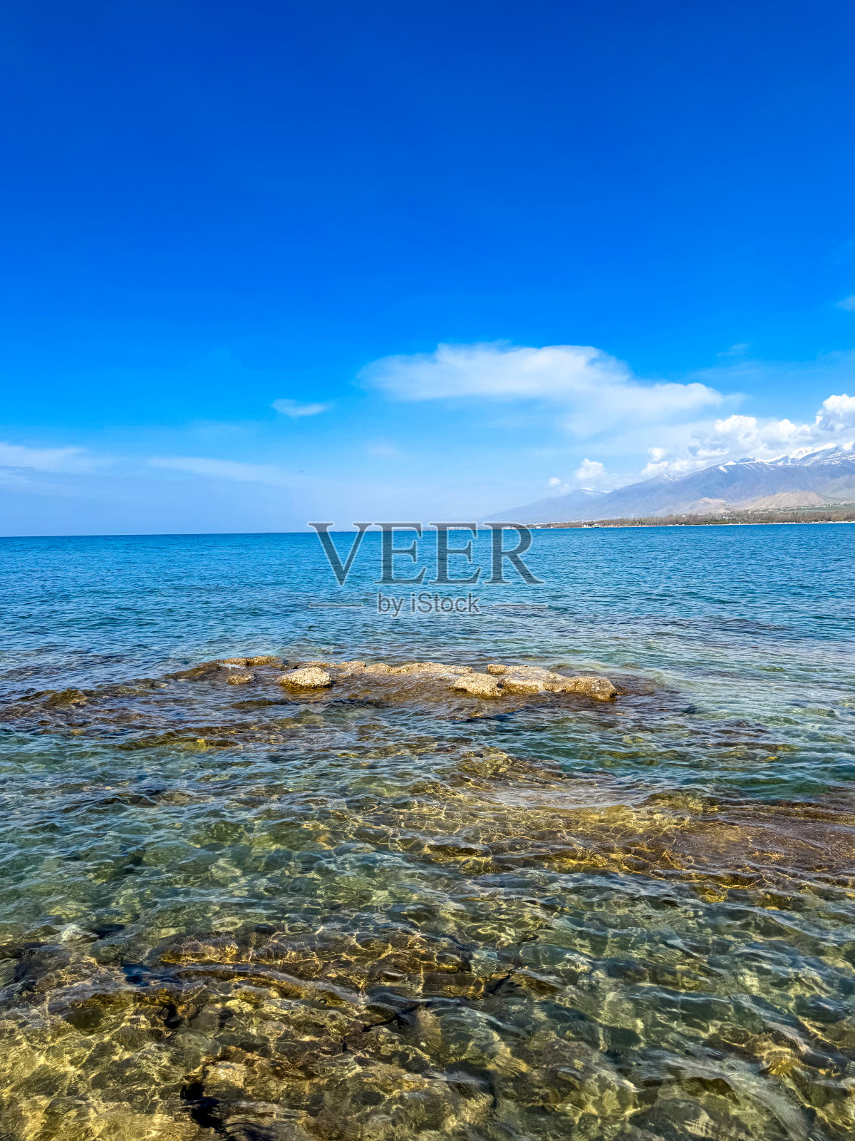阳光明媚的夏日在湖上。山和海。吉尔吉斯斯坦，伊塞克湖照片摄影图片
