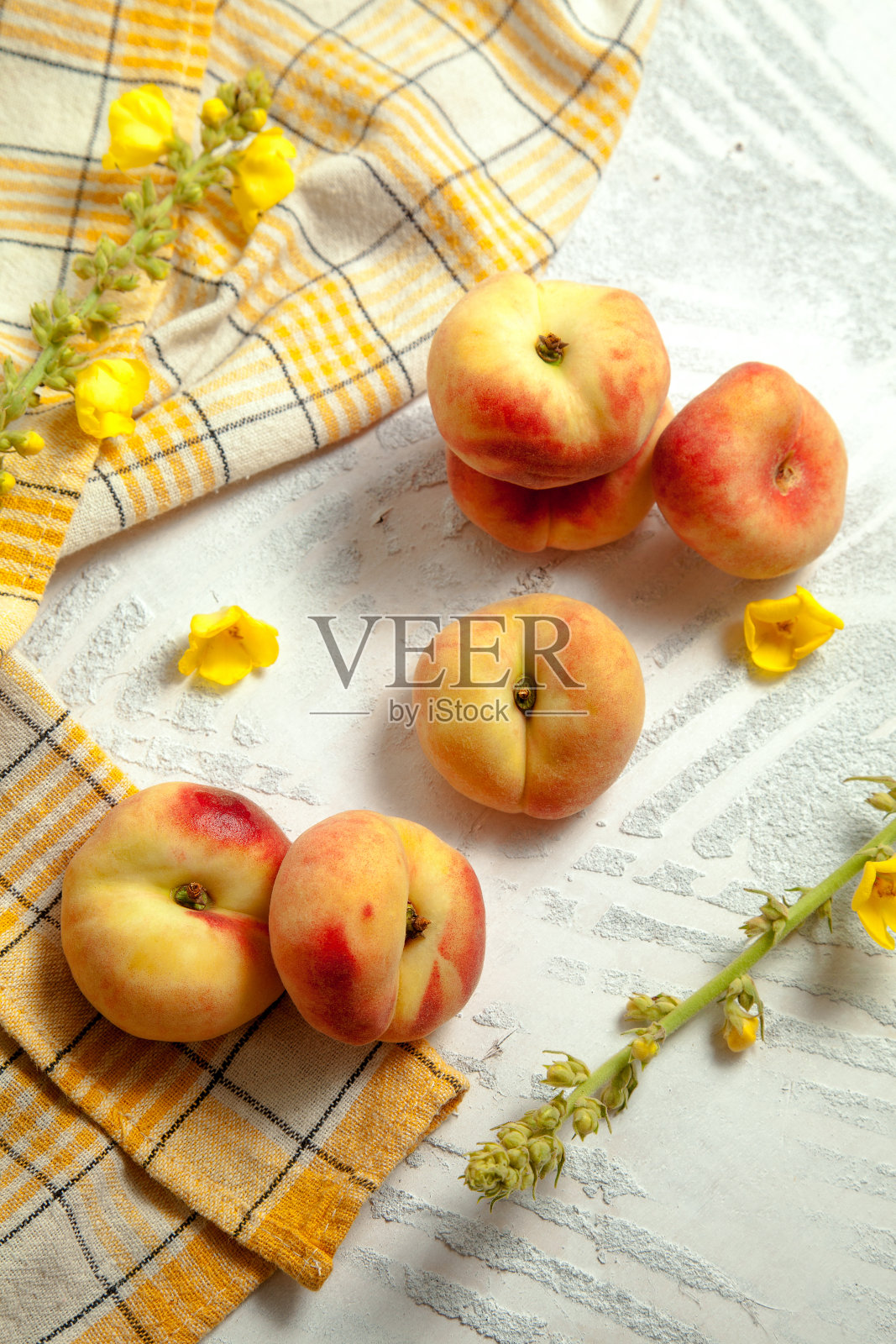 几个完整的土星桃或平桃在白色木制背景。照片摄影图片